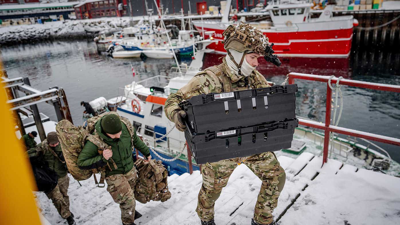 Danish troops unload equipment as they land in Greenland.