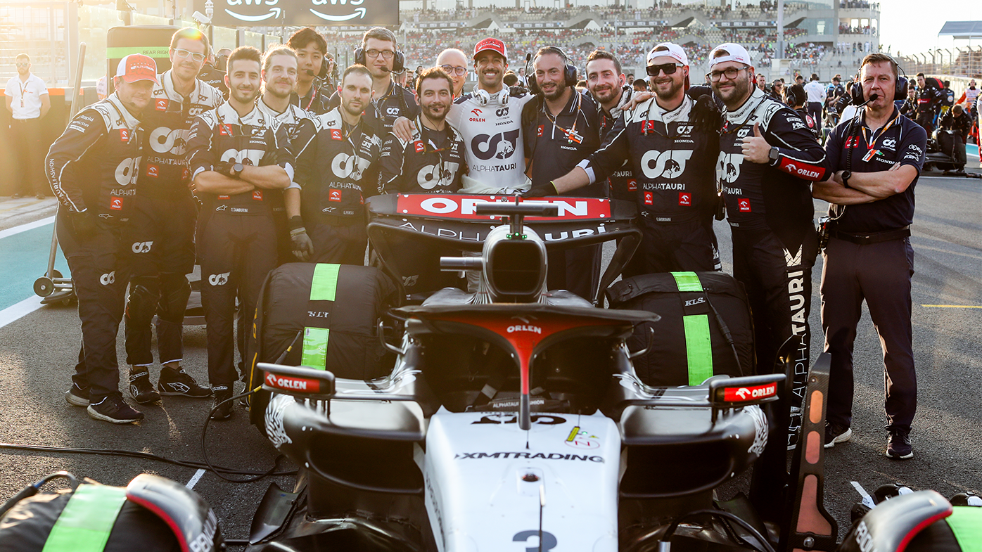 Daniel Ricciardo with his Scuderia AlphaTauri car crew on the grid ahead of the Abu Dhabi Grand Prix.