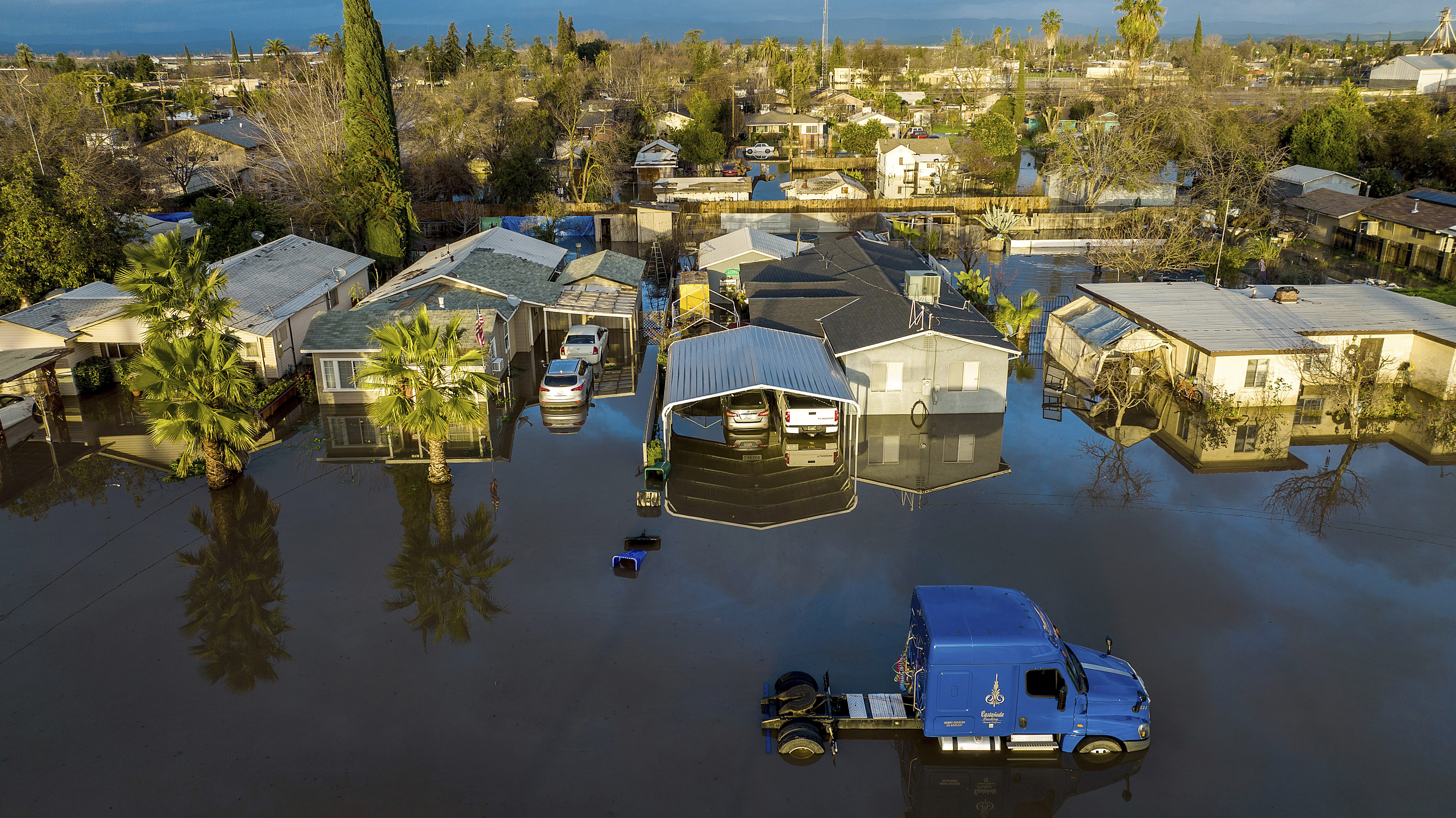 Following days of rain, floodwaters surround homes and vehicles in the Planada community of Merced County, Calif., on Tuesday, Jan. 10, 2023.