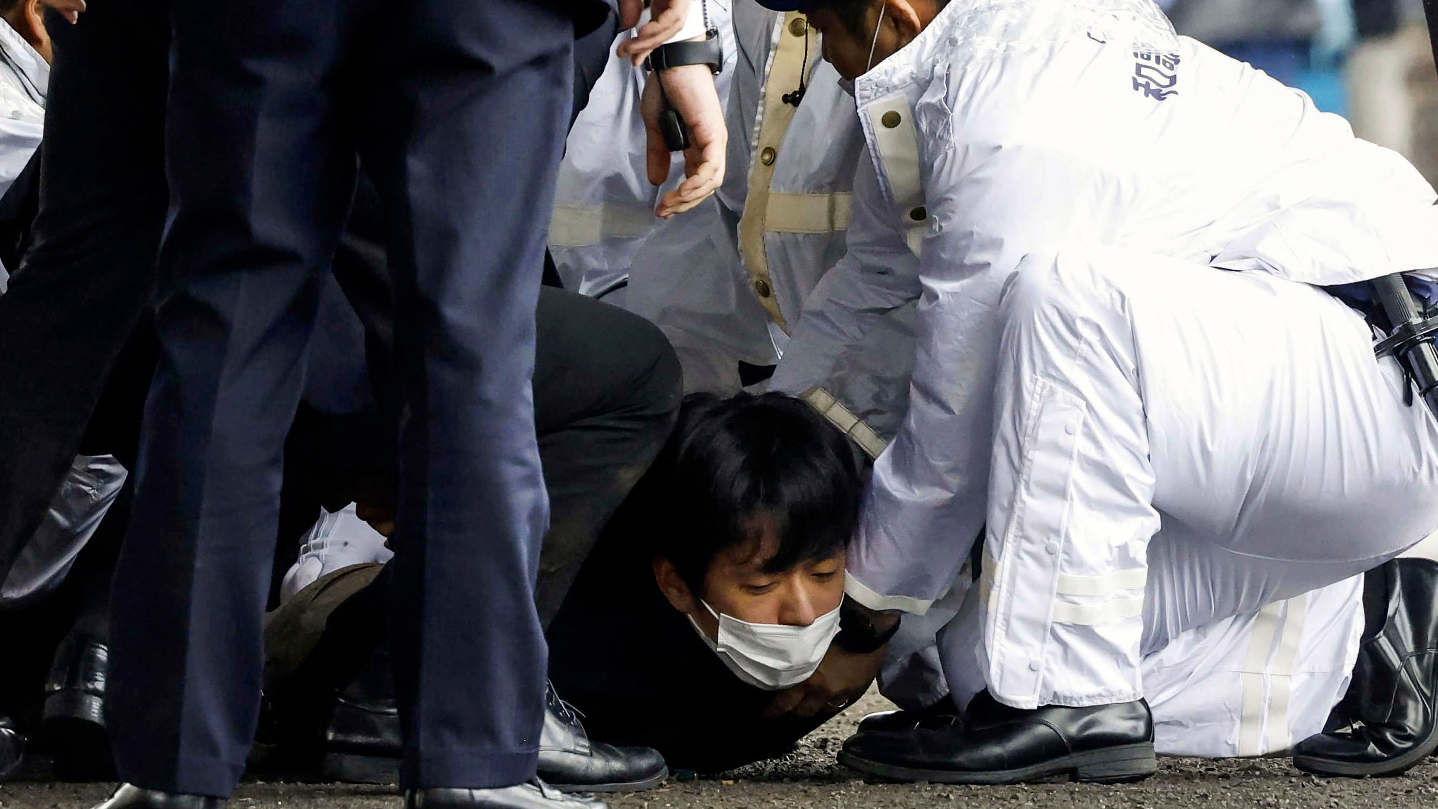 A man, on the ground, who threw what appeared to be a smoke bomb, is arrested by police.