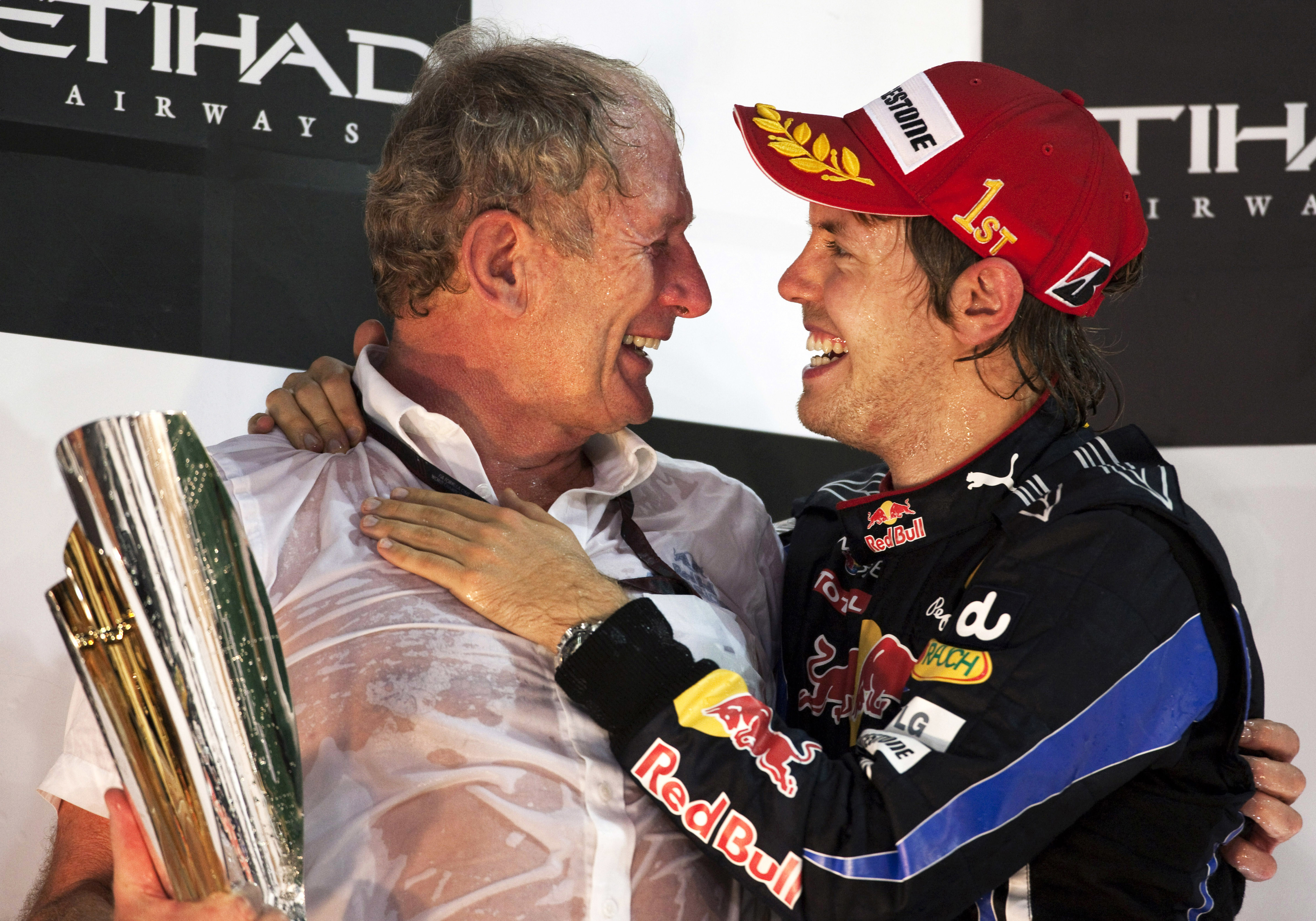 Red Bull Racing's Helmut Marko celebrates on the winners podium with Sebastian Vettel in 2010.