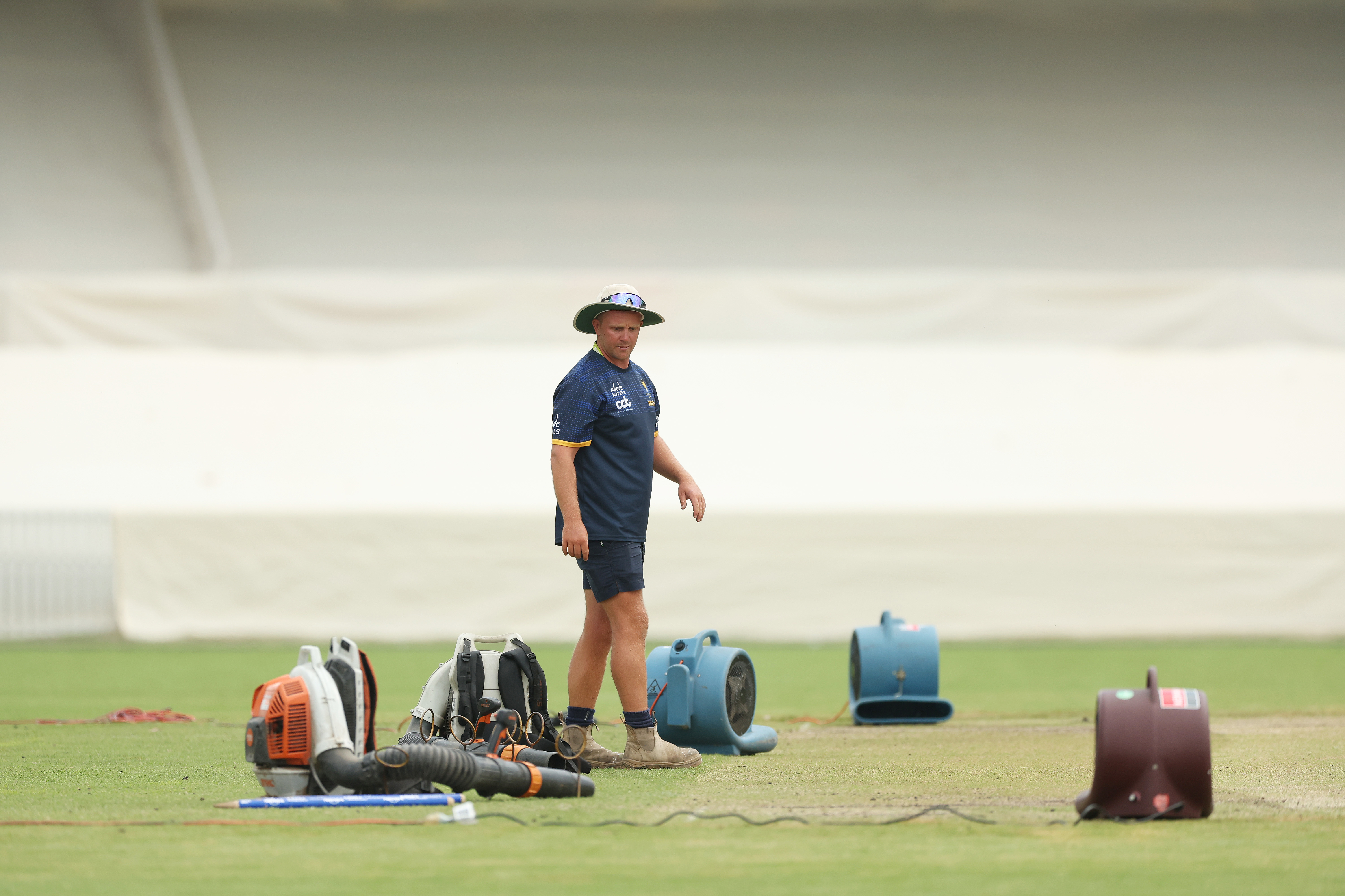Groundstaff attend to blowers attempting to dry the wicket during a delay to the start of play due to an overnight storm during day four of the Tour match between PMs XI and Pakistan at Manuka Oval on December 09, 2023 in Canberra, Australia. (Photo by Mark Metcalfe/Getty Images)