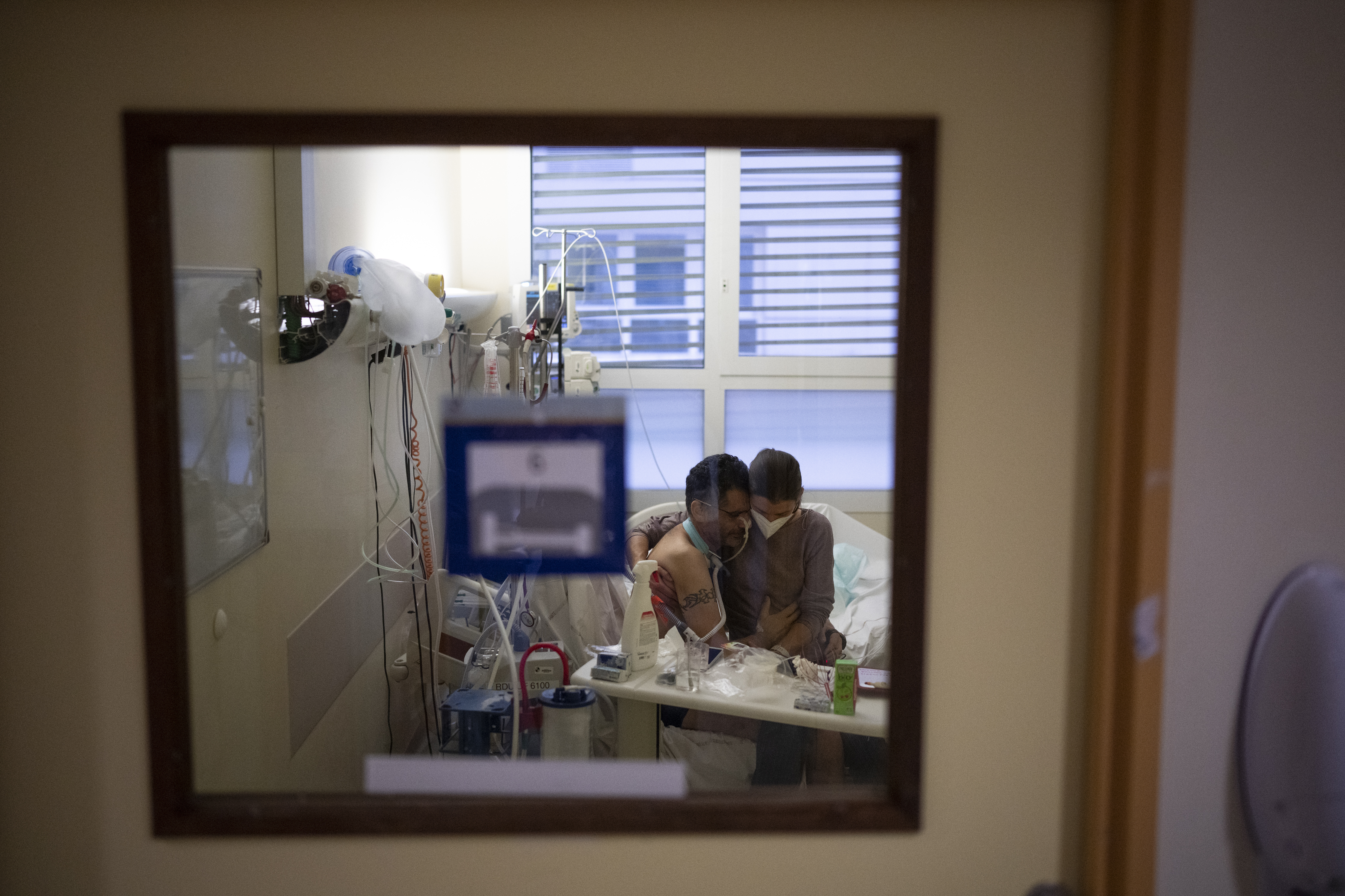 Amelie and Ludo Khayat hold each other during a visit at the COVID-19 intensive care unit of the la Timone hospital in Marseille, southern France, Thursday, Dec. 23, 2021. 
