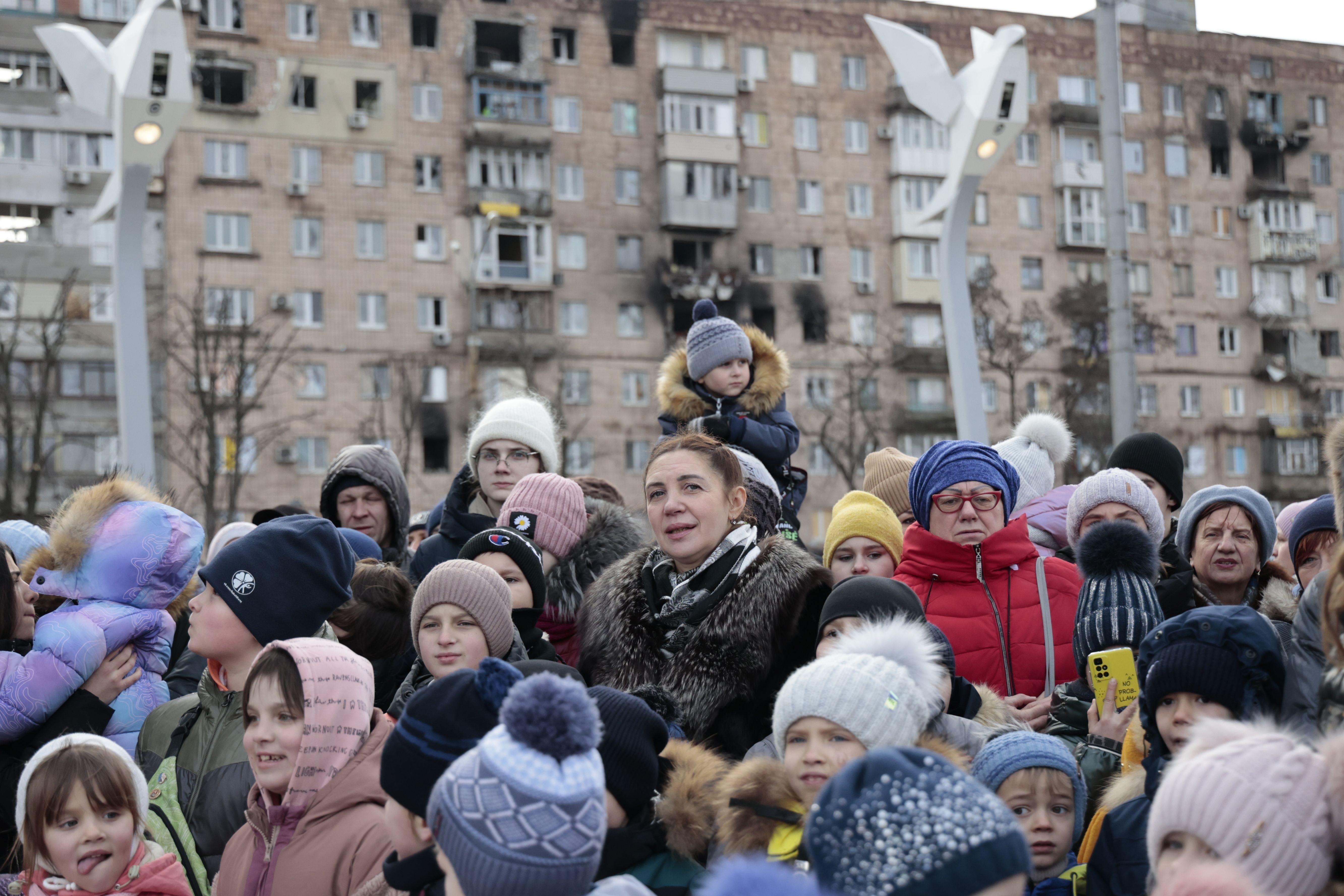 Ciudadanos locales observan una actuación cerca de un árbol de Navidad decorado para las festividades de Navidad ortodoxa y Año Nuevo en Mariupol, en la región de Donetsk controlada por Rusia, en el este de Ucrania, el jueves 5 de enero de 2023. (Foto AP/Alexei Alexandrov)