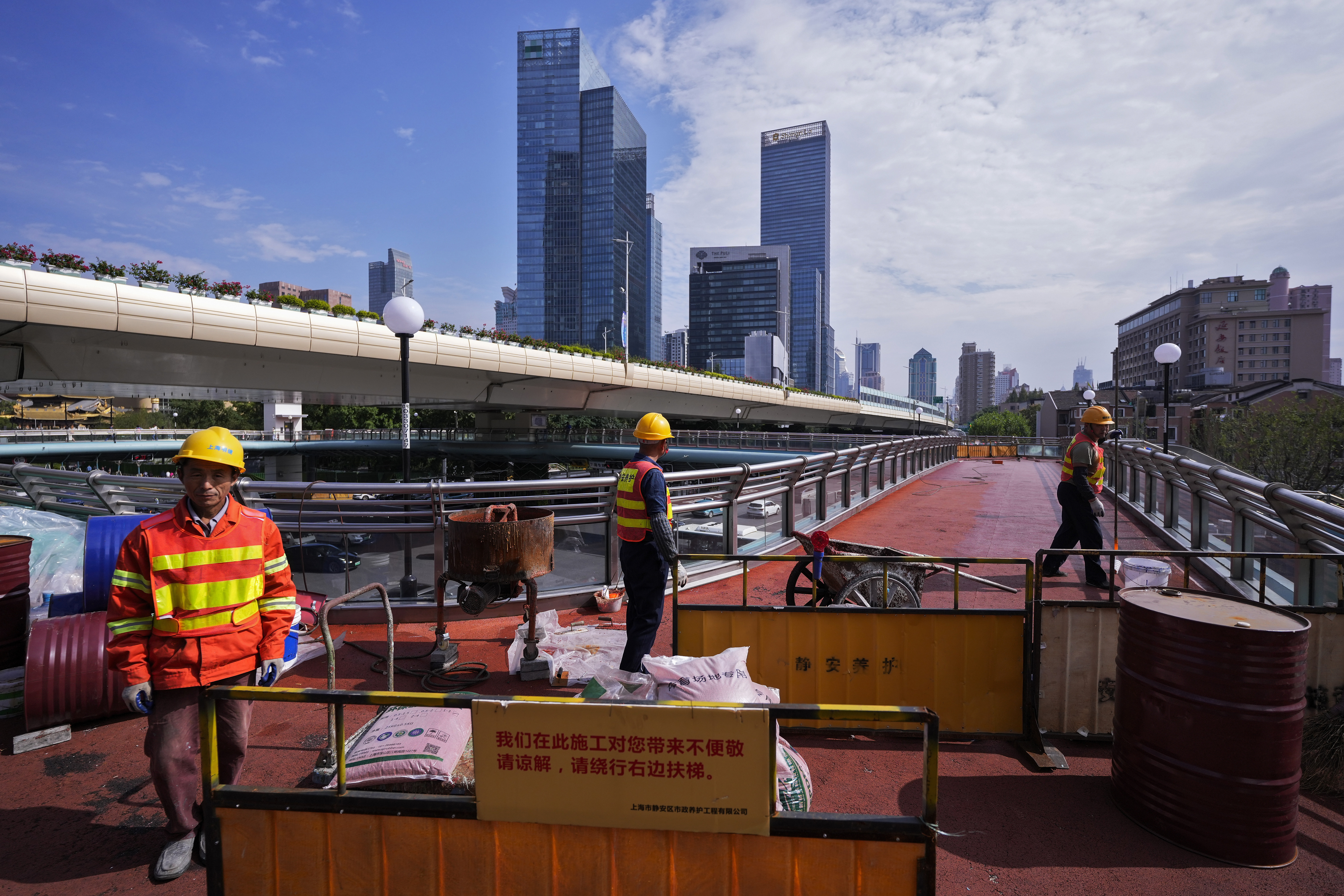 Trabajadores remodelan un puente peatonal elevado en Shanghai el 9 de octubre de 2024 