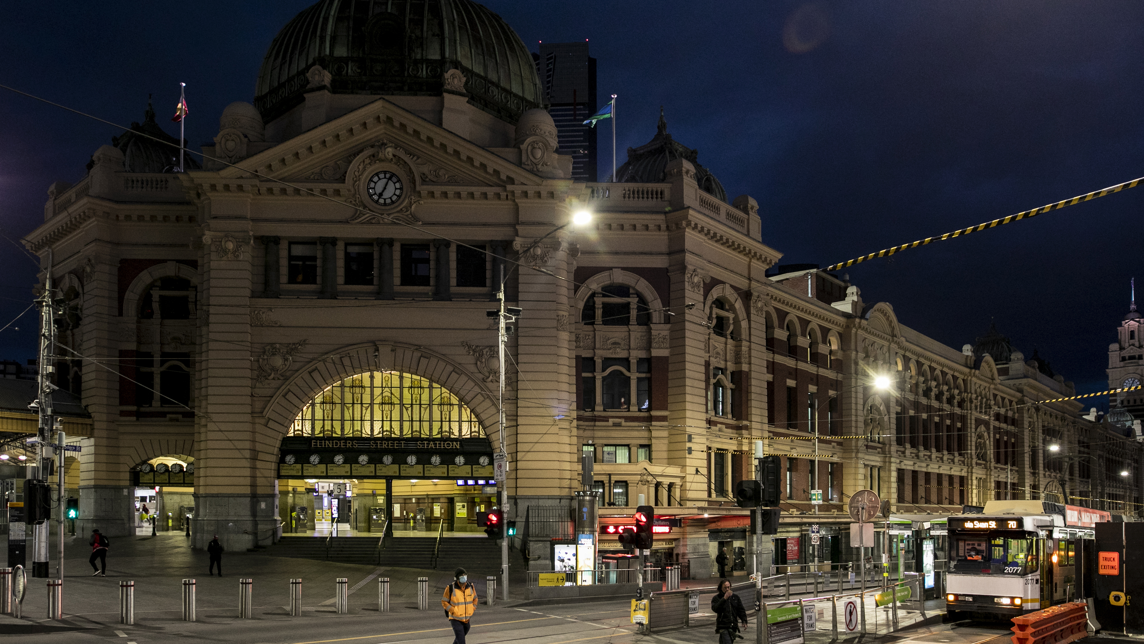 People crossing Flinders Street amid lockdown in Melbourne, Australia. 