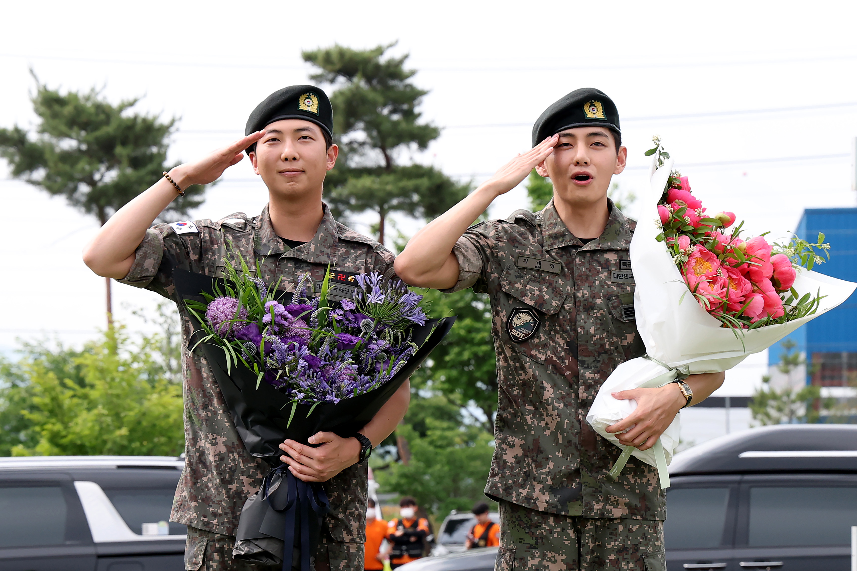 K-pop band BTS's members RM (L) and V (R) react after being discharged from a mandatory military service