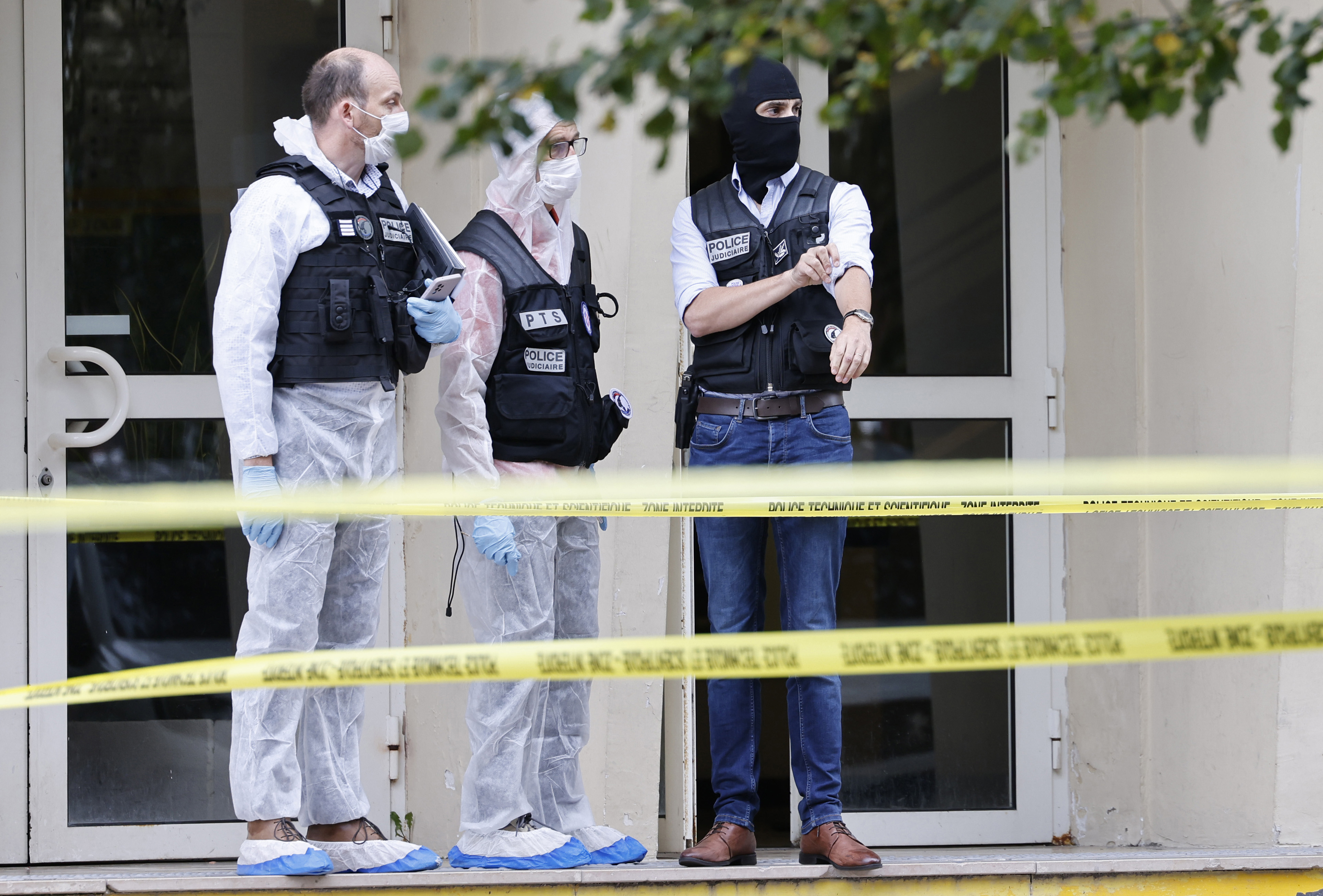 French investigating officers stand in front of the Gambetta high school in Arras, northeastern France, after a man armed with a knife killed a teacher and wounded another teacher and a security guard, an attack being investigated as potential terrorism, Friday Oct. 13, 2023.