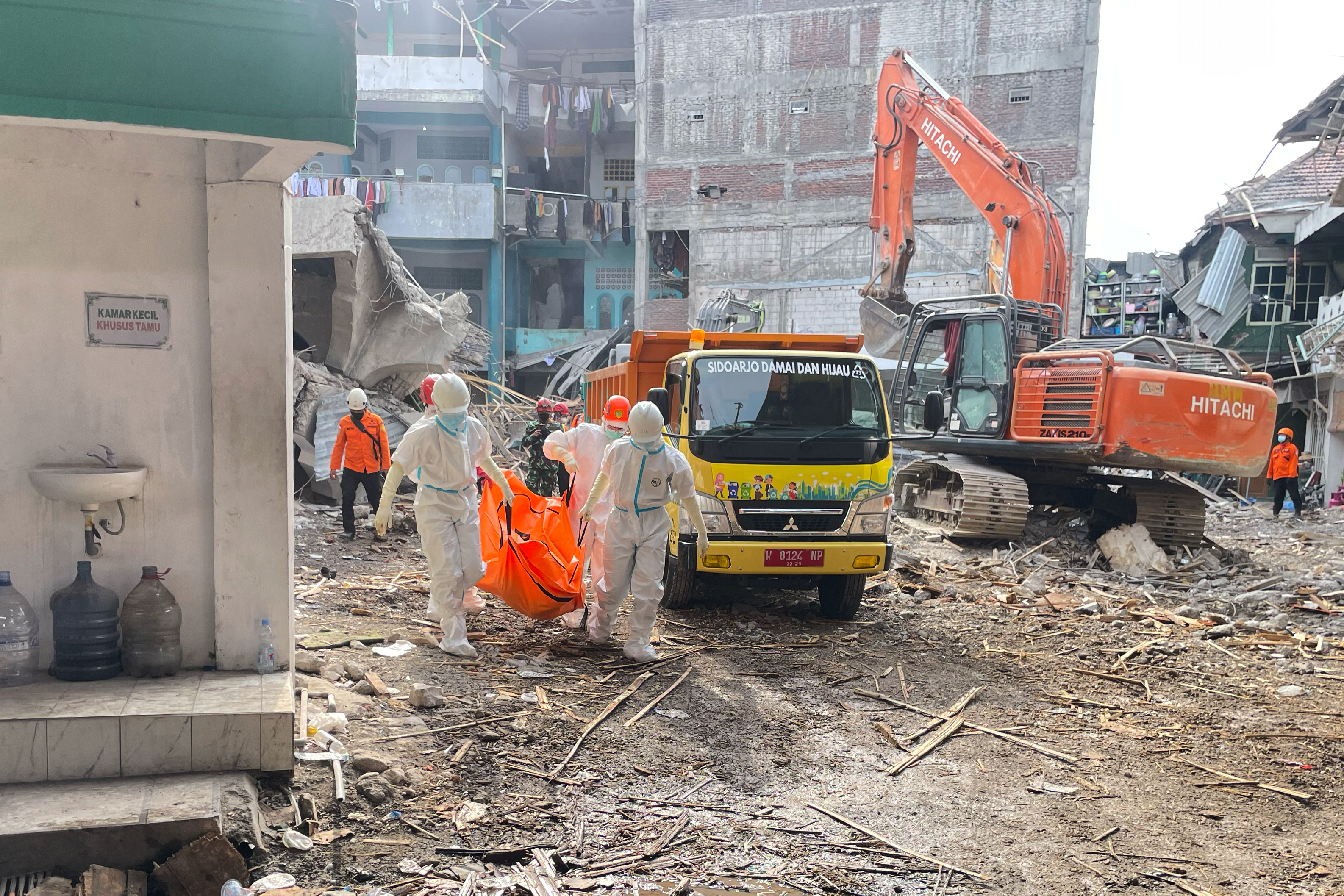 Rescuers carry the body of a newly recovered victim of a building that collapsed at an Islamic boarding school in Sidoarjo, East Java, Indonesia, Sunday, Oct. 5, 2025. (AP Photo/Trisnadi)