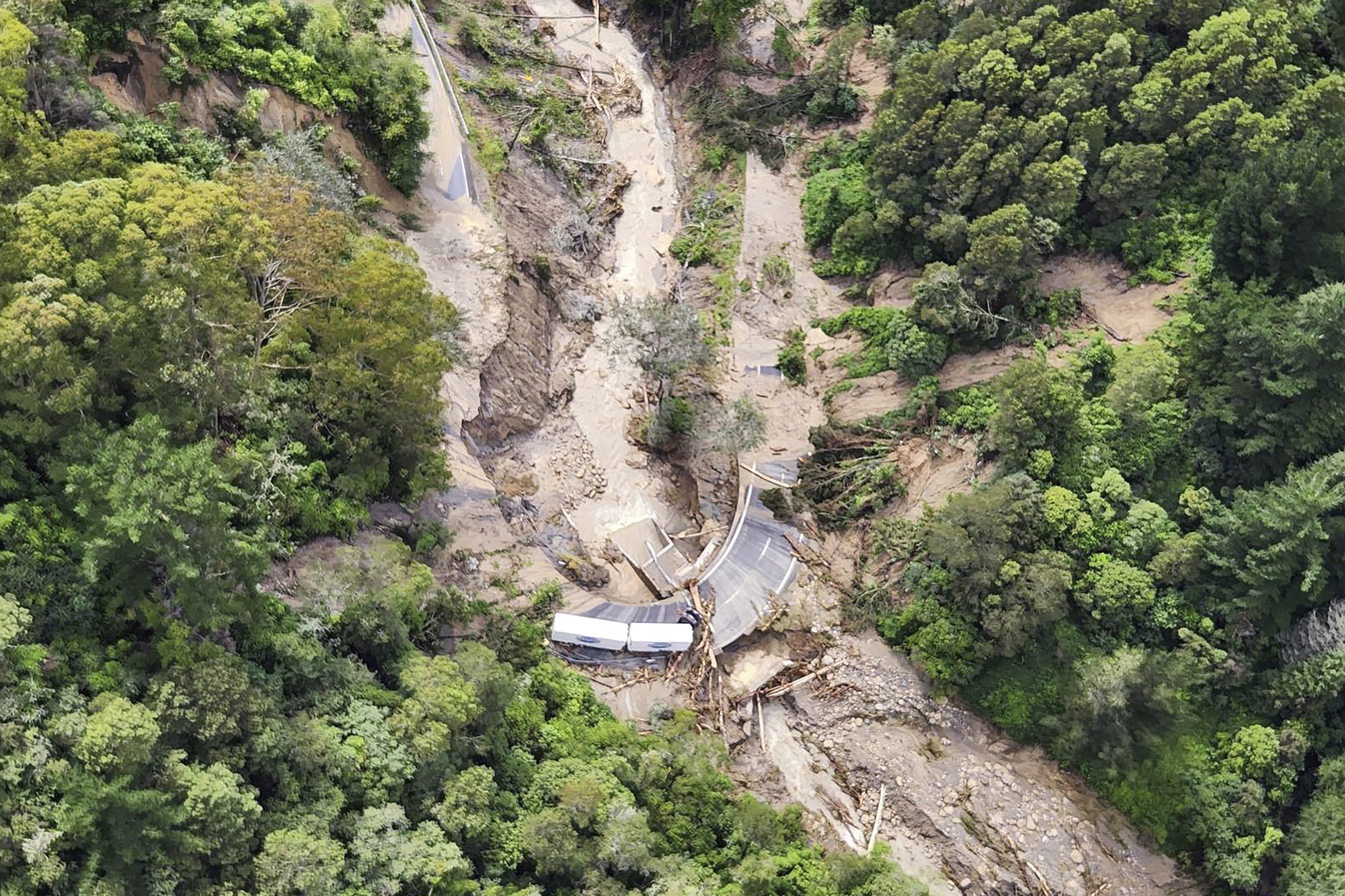 In this image released by the New Zealand Defence Force on Wednesday, Feb. 15, 2023, a road between Napier and Wairoa is washed out by flood water. The New Zealand government declared a national state of emergency Tuesday after Cyclone Gabrielle battered the country's north in what officials described as the nation's most severe weather event in years. (New Zealand Defense Force via AP)