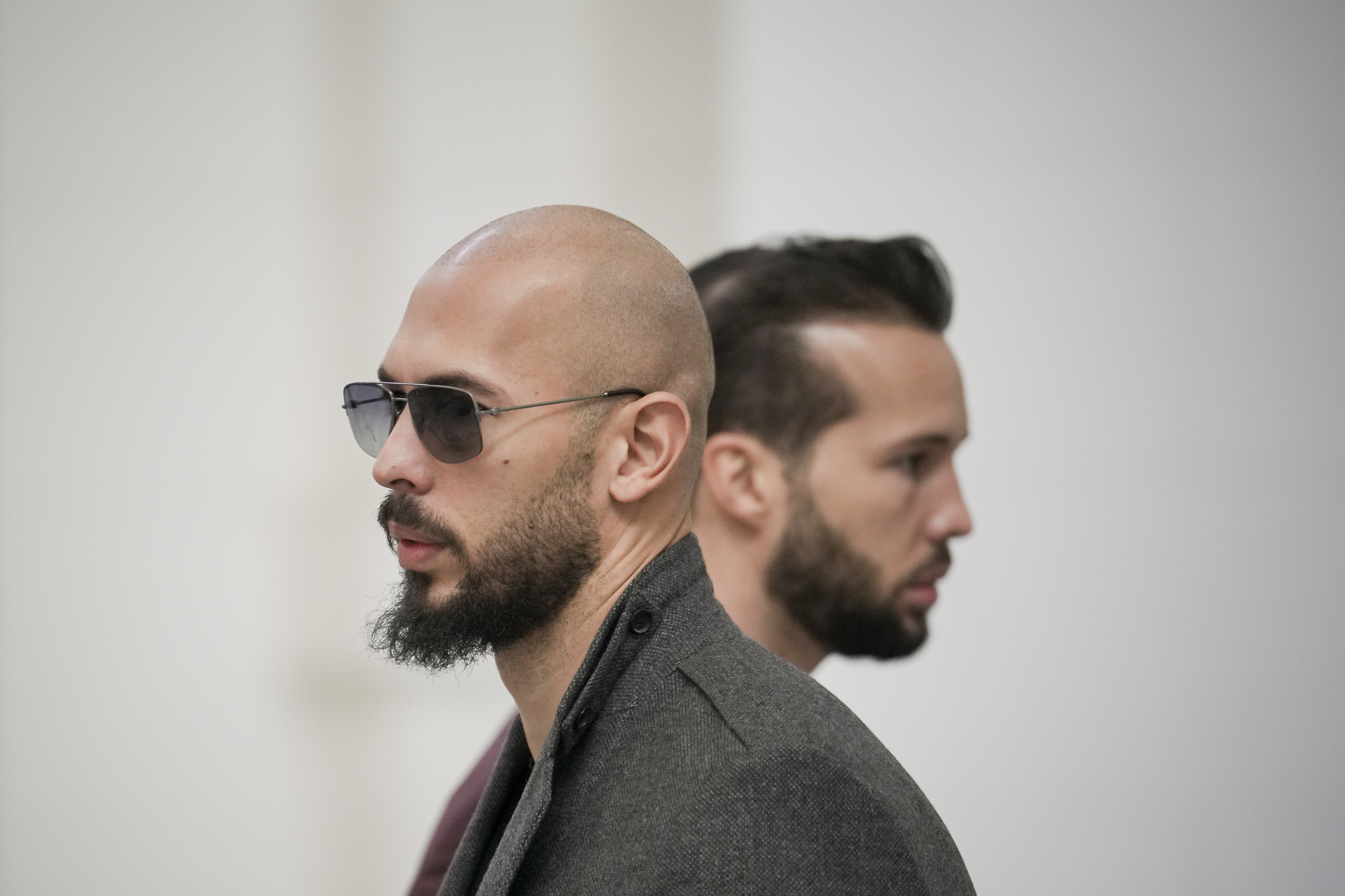 Andrew Tate, left, and his brother Tristan, right, wait inside the Court of Appeals building in Bucharest, Romania, Tuesday, Jan. 30, 2024 