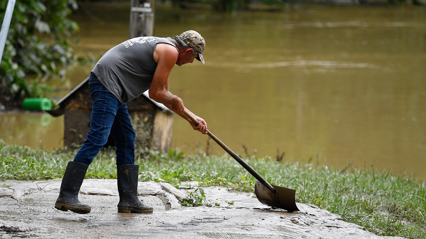 Junior Bowling palea lodo y sedimento de las inundaciones en Jackson, Kentucky, el viernes 29 de julio de 2022. 