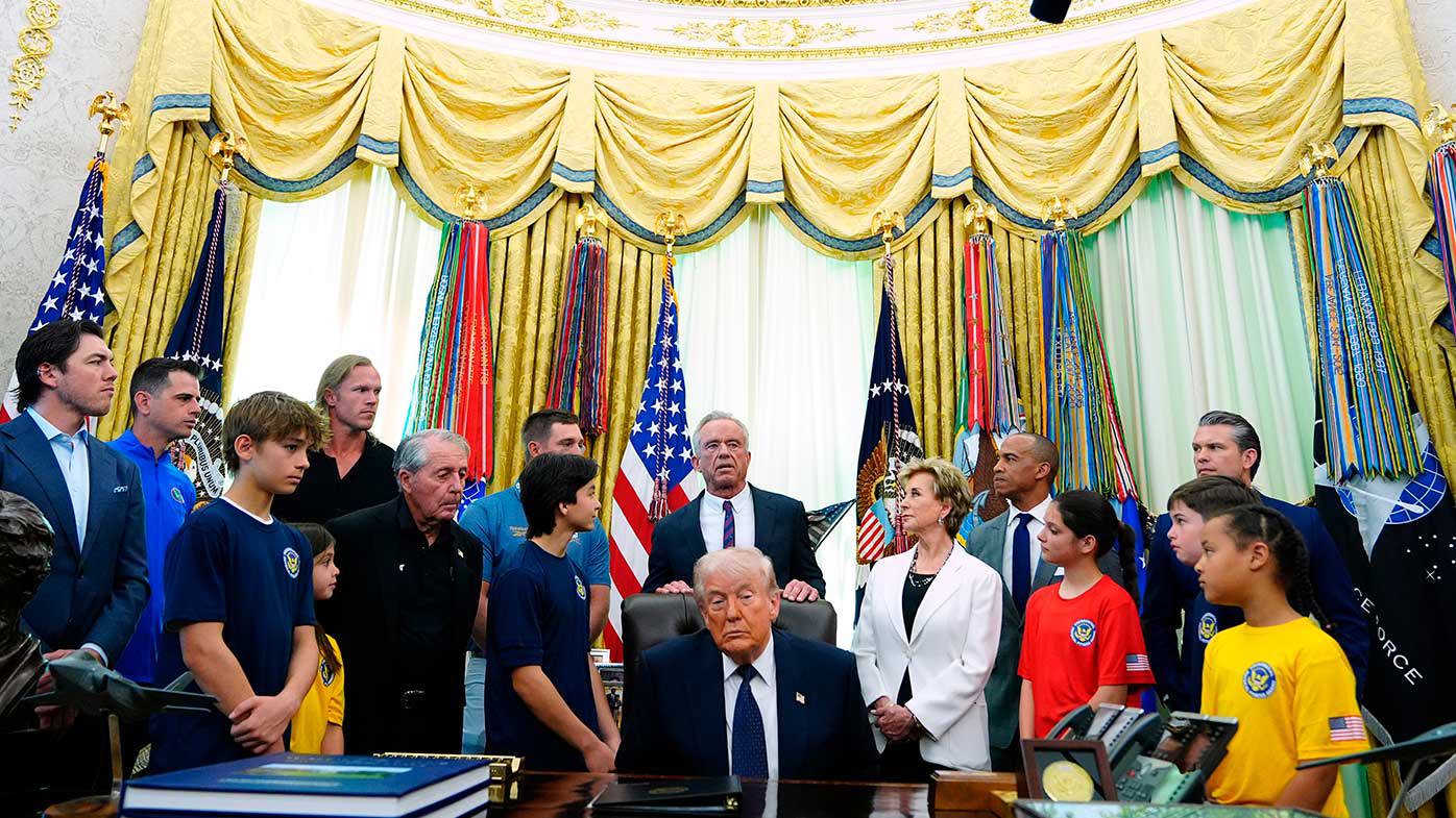 Donald Trump surrounded by cabinet members and children.