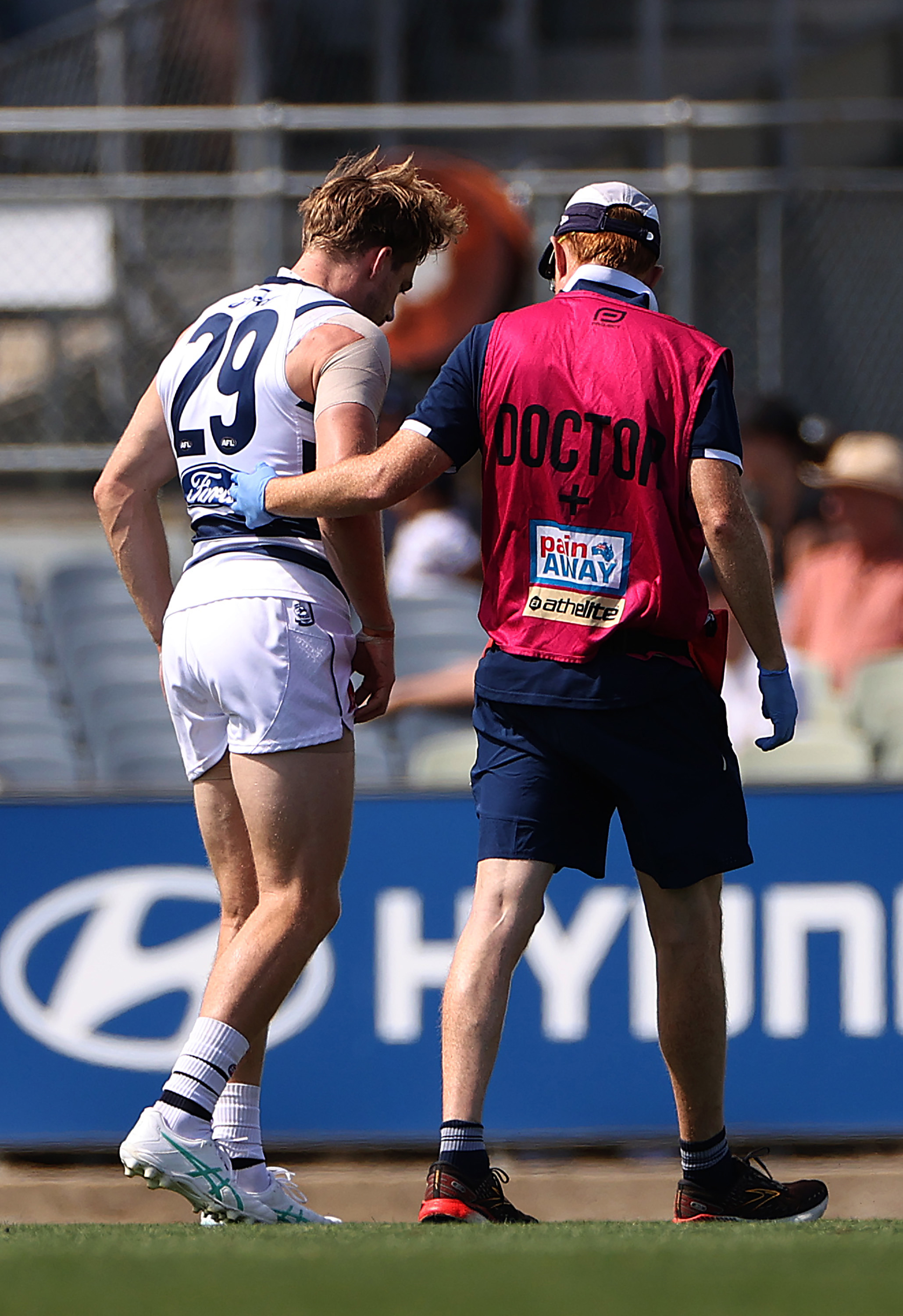 Cam Guthrie is helped off the ground with the Cats doctor.