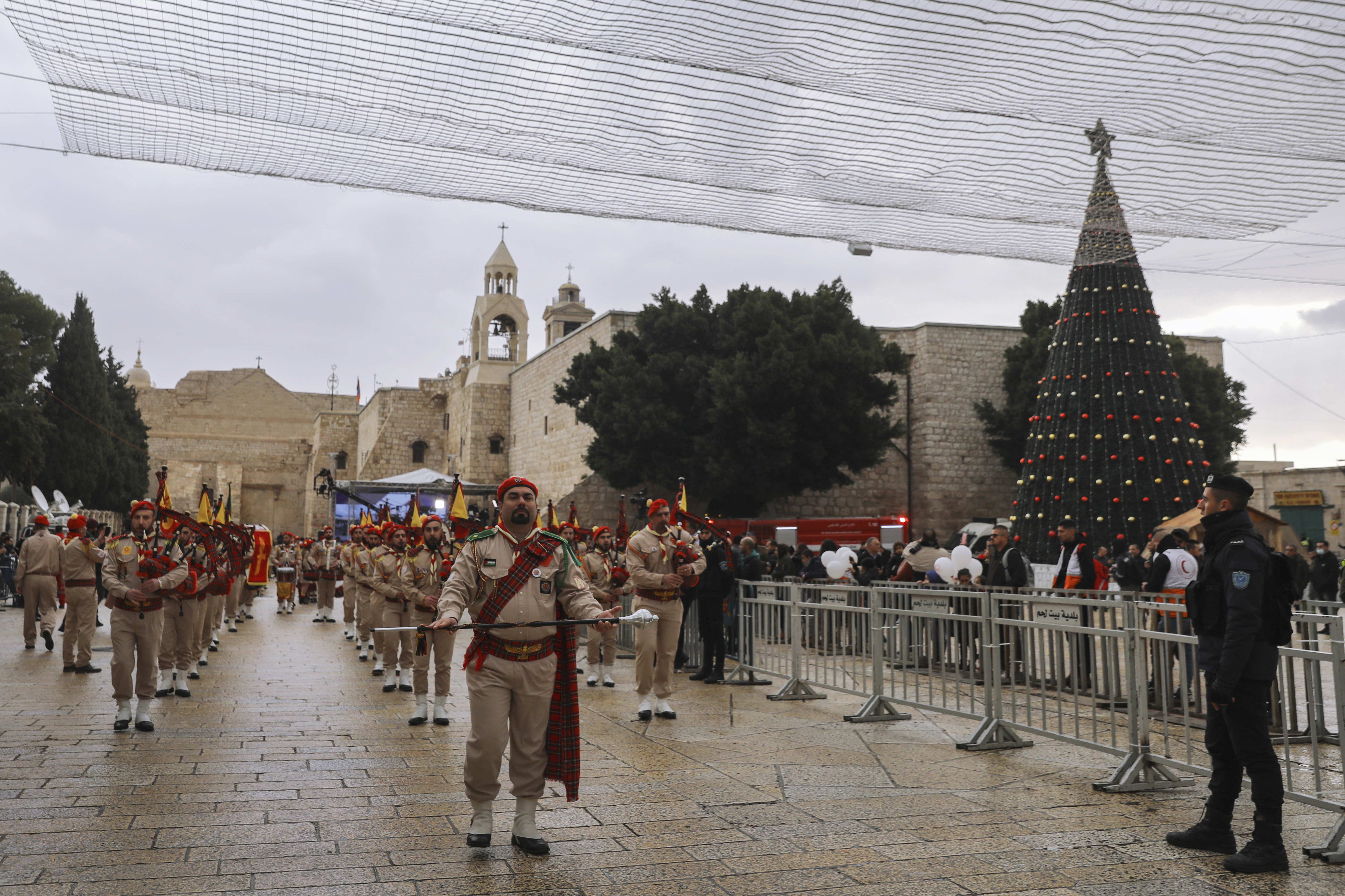 Palestinian scout bands parade through Manger Square at the Church of the Nativity,  traditionally believed to be the birthplace of Jesus Christ, during Christmas celebrations, in the West Bank city of Bethlehem, Friday, Dec. 24, 2021. 
