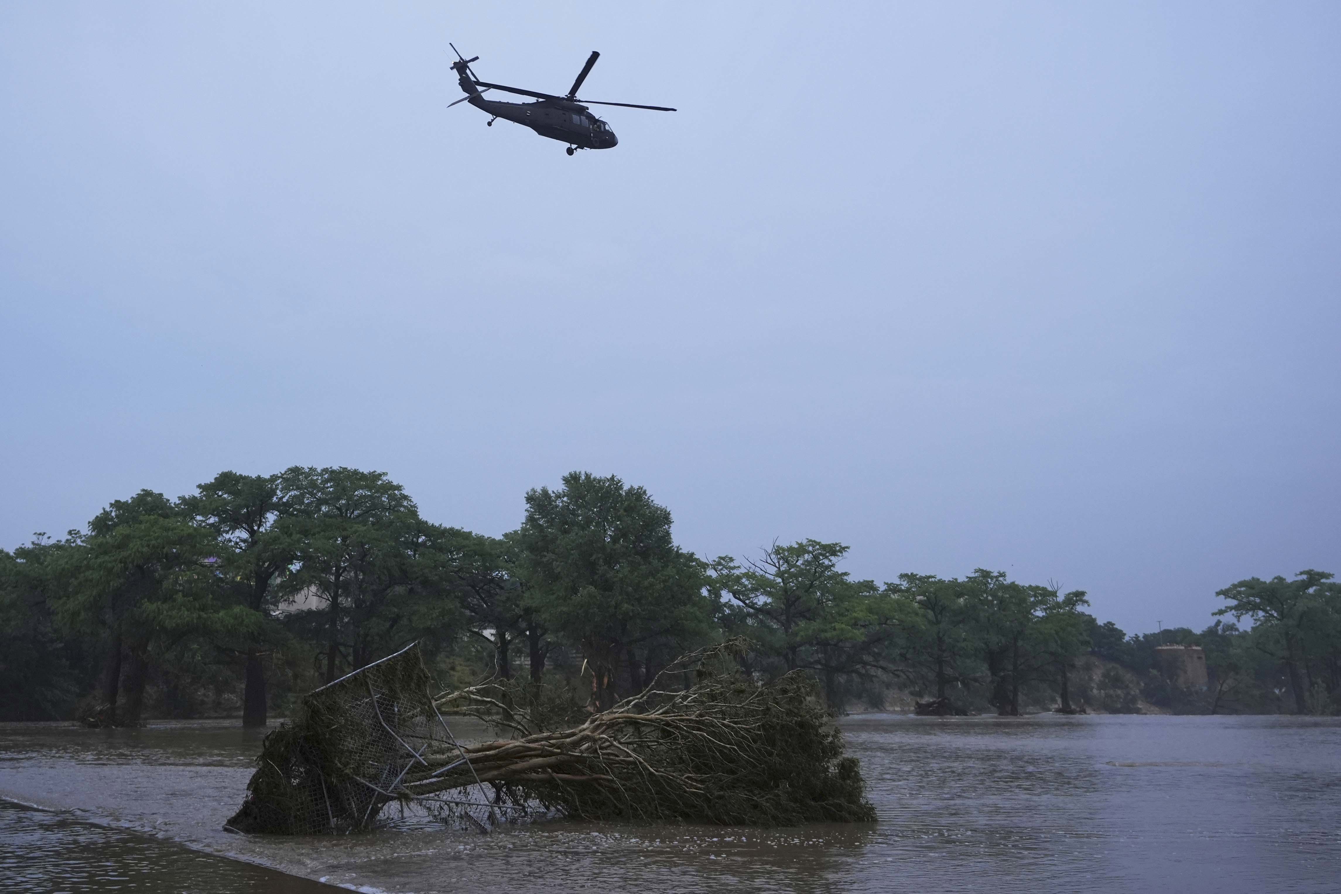 A helicopter flies over the Guadalupe River after a flash flood swept through the area, in Kerrville, Texas.