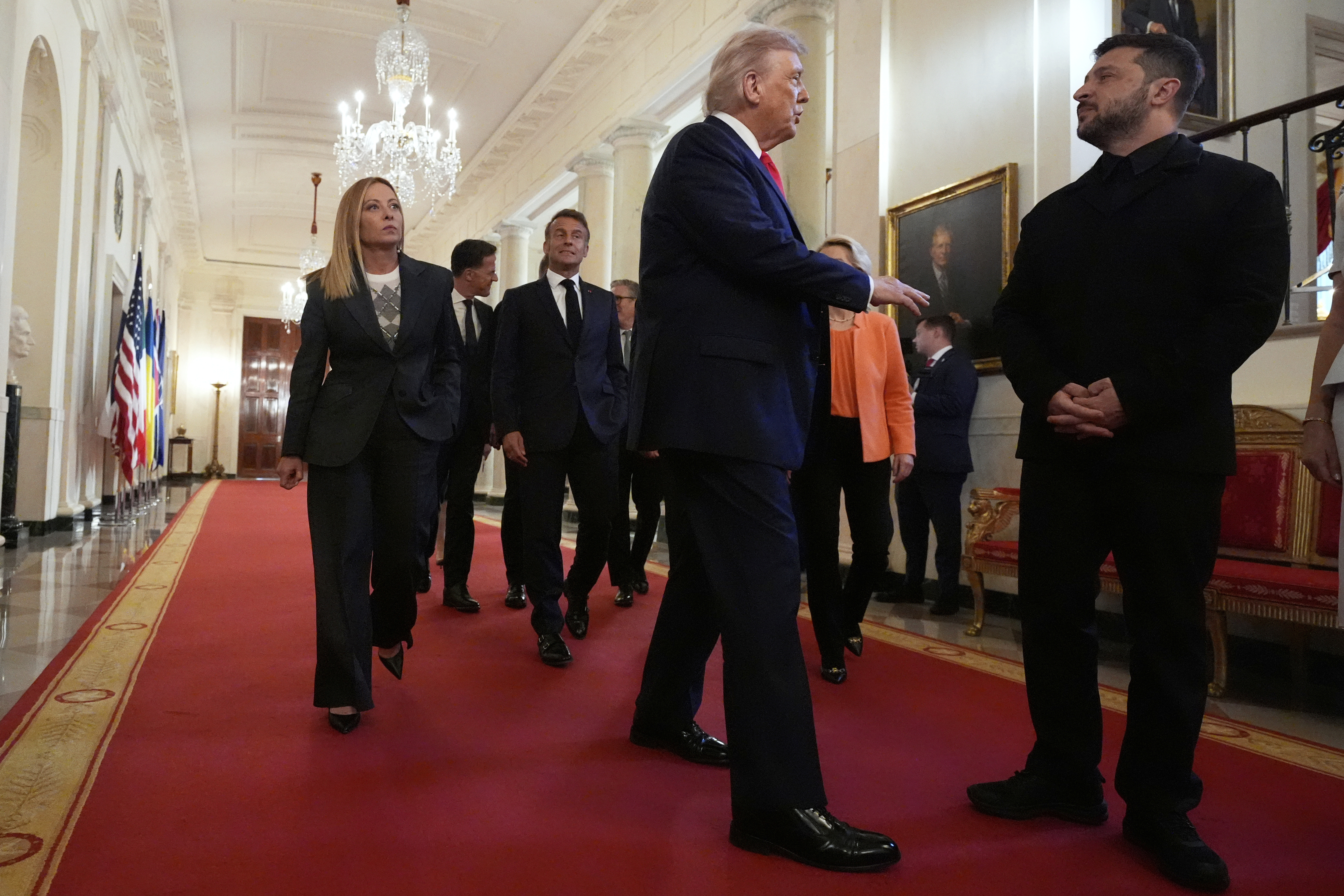 Ukrainian President Volodymyr Zelenskyy, from right, President Donald Trump, France's President Emmanuel Macron and Italy's Prime Minister Giorgia Meloni walk through the Cross Hall of the White House, Monday, Aug. 18, 2025, in Washington.
