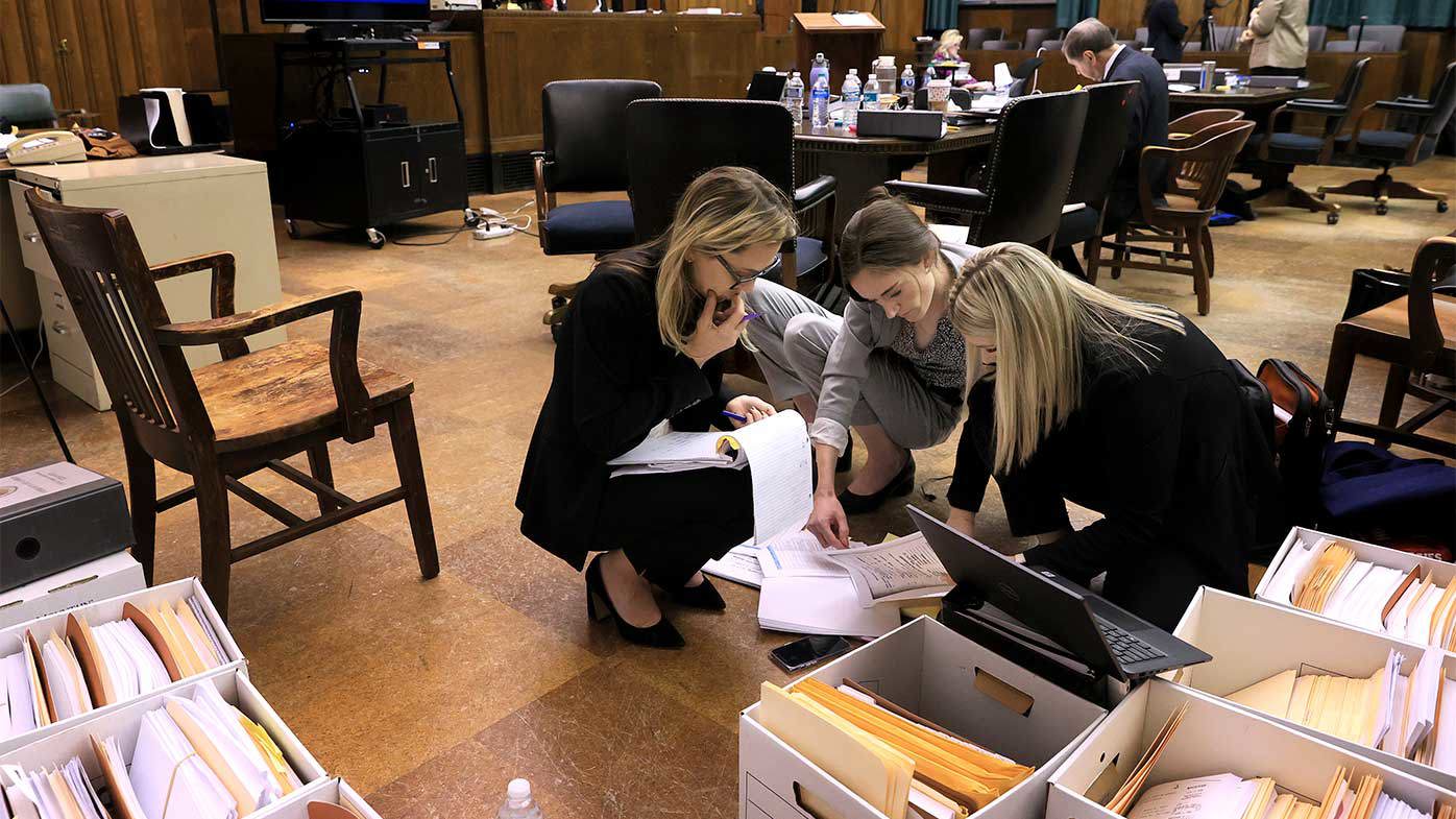 Las abogadas Lindsay Runnels y Kylie Mank y la asistente legal Maci Morgan revisan las cajas de pruebas antes de que la corte se reinicie después de un descanso para almorzar durante el cuarto día de la audiencia de condena injusta de Lamar Johnson.