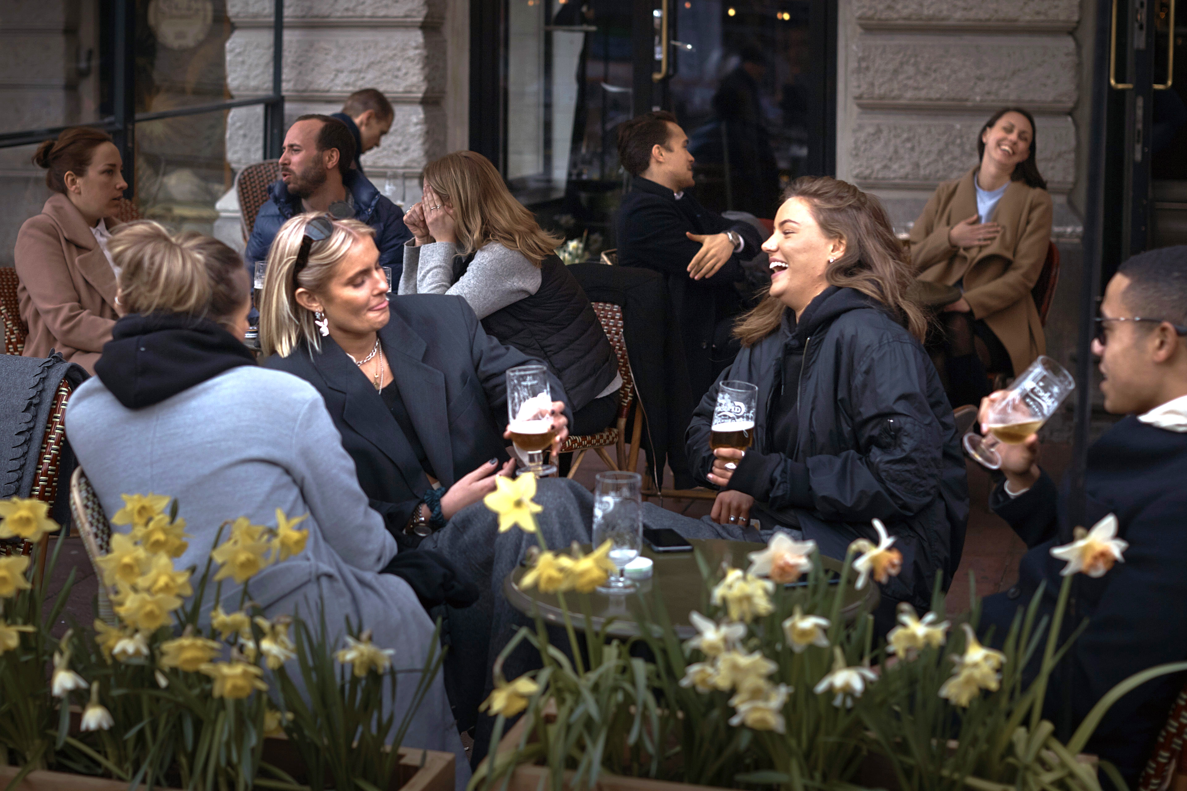 In this April photo, people chat and drink outside a bar in Stockholm, Sweden. Sweden's relatively low-key approach to coronavirus lockdowns captured the world's attention when the pandemic first hit Europe.