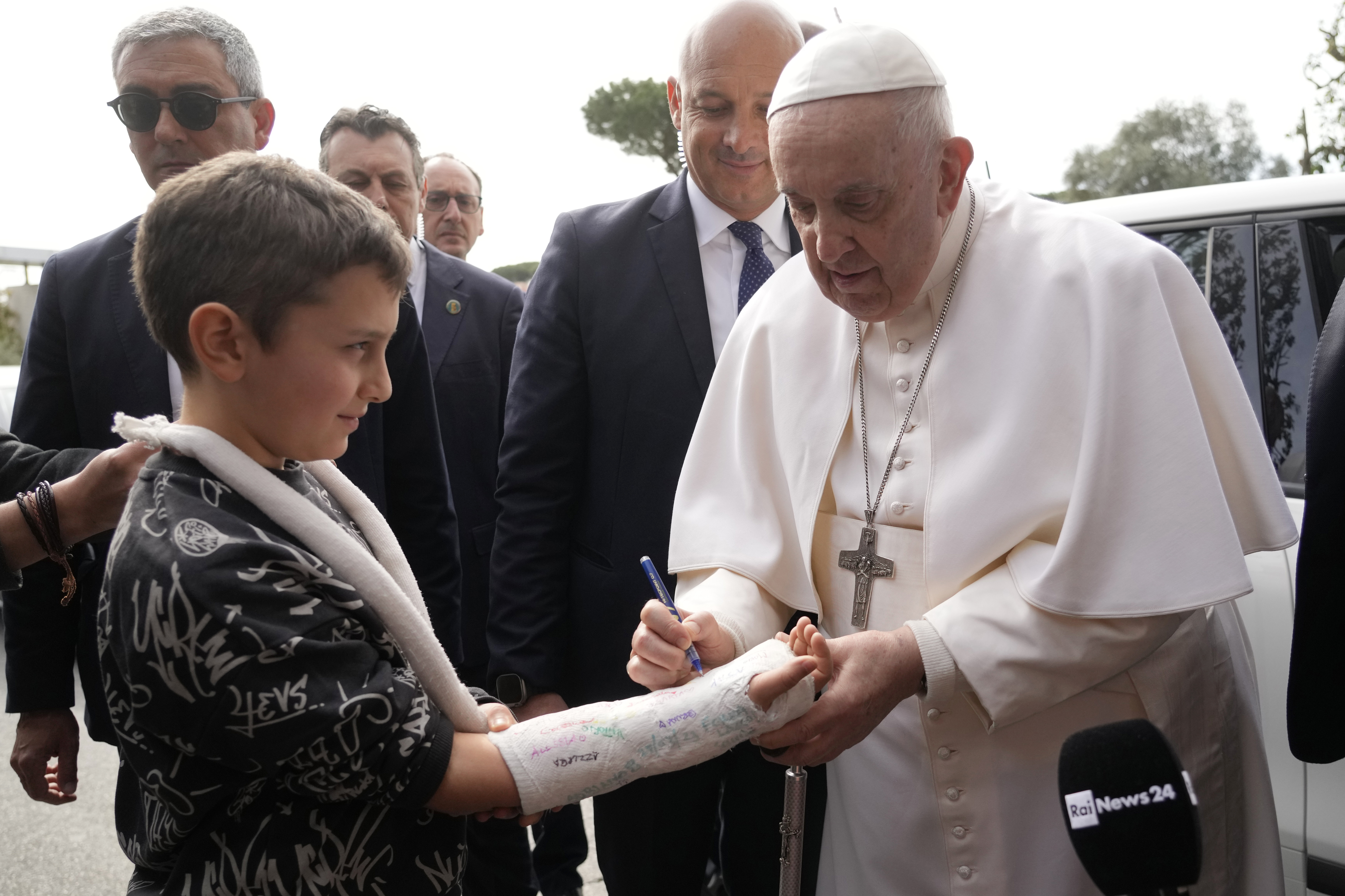 Pope Francis autographs the plaster cast of a child as he leaves the Agostino Gemelli University Hospital in Rome, Saturday, April 1, 2023 after receiving treatment for a bronchitis, The Vatican said. 