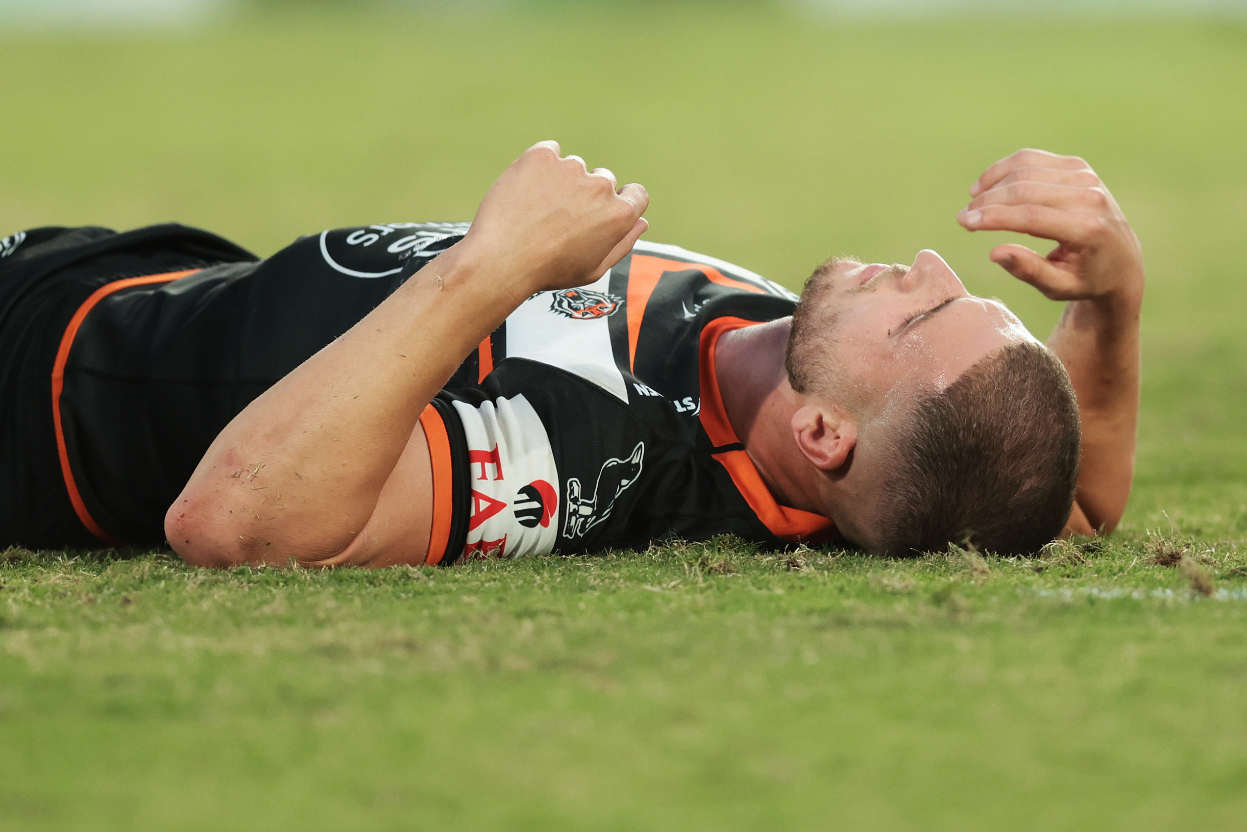 Adam Doueihi of the Wests Tigers lays on the field injured during the round six NRL match between Wests Tigers and Parramatta Eels at Accor Stadium on April 10, 2023 in Sydney, Australia. (Photo by Mark Metcalfe/Getty Images)
