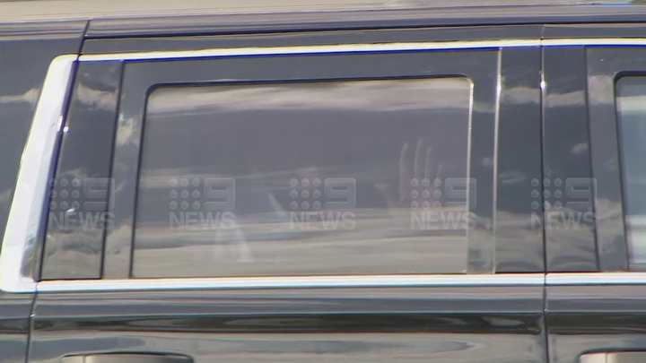 Donald Trump waves at supporters as he leaves his gold club.