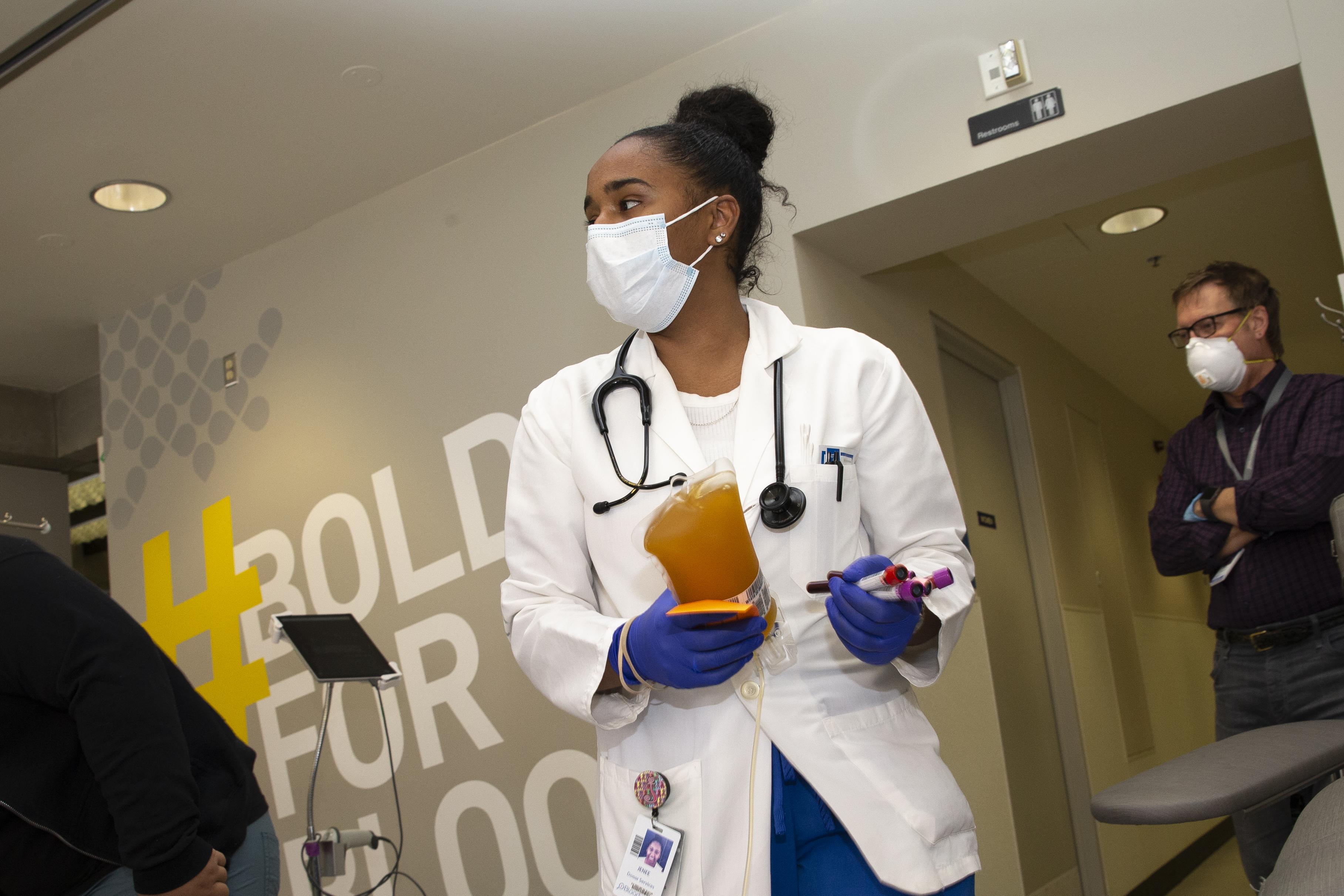 Phlebotomist, Jenee Wilson carries COVID-19 convalescent plasma from a donor at Bloodworks Northwest on April 17, 2020 in Seattle, Washington. The plasma donation process, called plasmapheresis, separates blood plasma, from red and white blood cells and platelets, and returns the cells and platelets back to the donor.