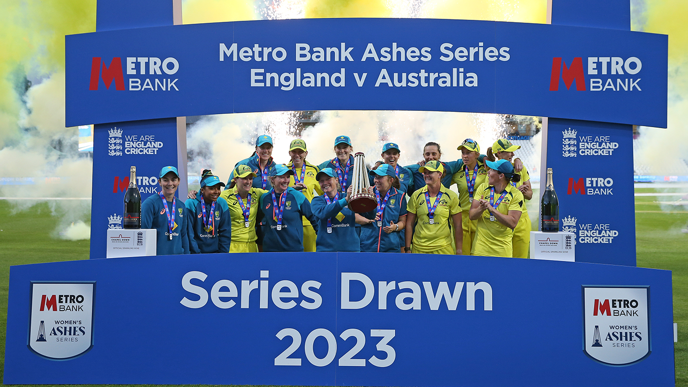 The Australian women's cricket team celebrate with the trophy after retaining the Ashes after the third ODI match against England.