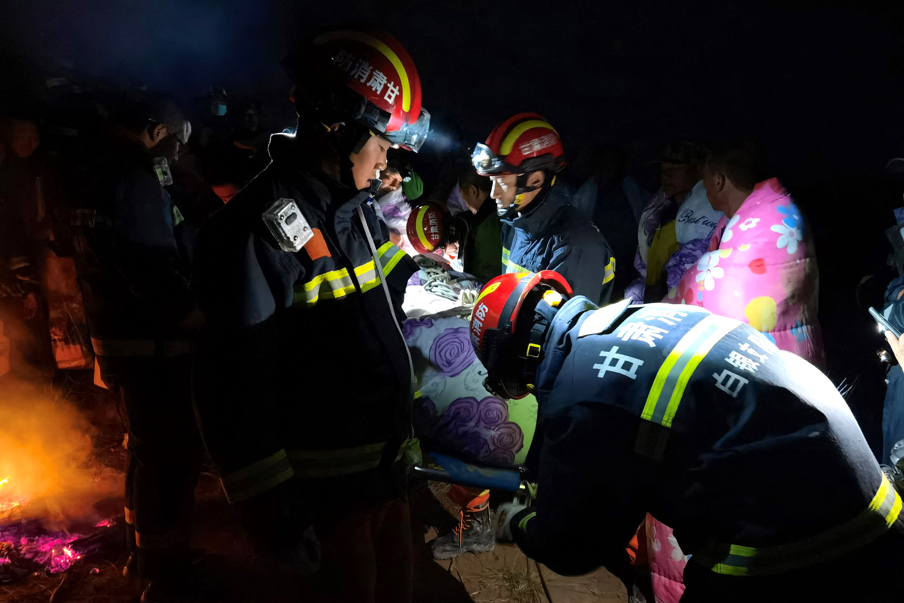 Rescuers assist people who were competing in a 100-kilometre mountain race when extreme weather hit the area, leaving at least 21 dead.