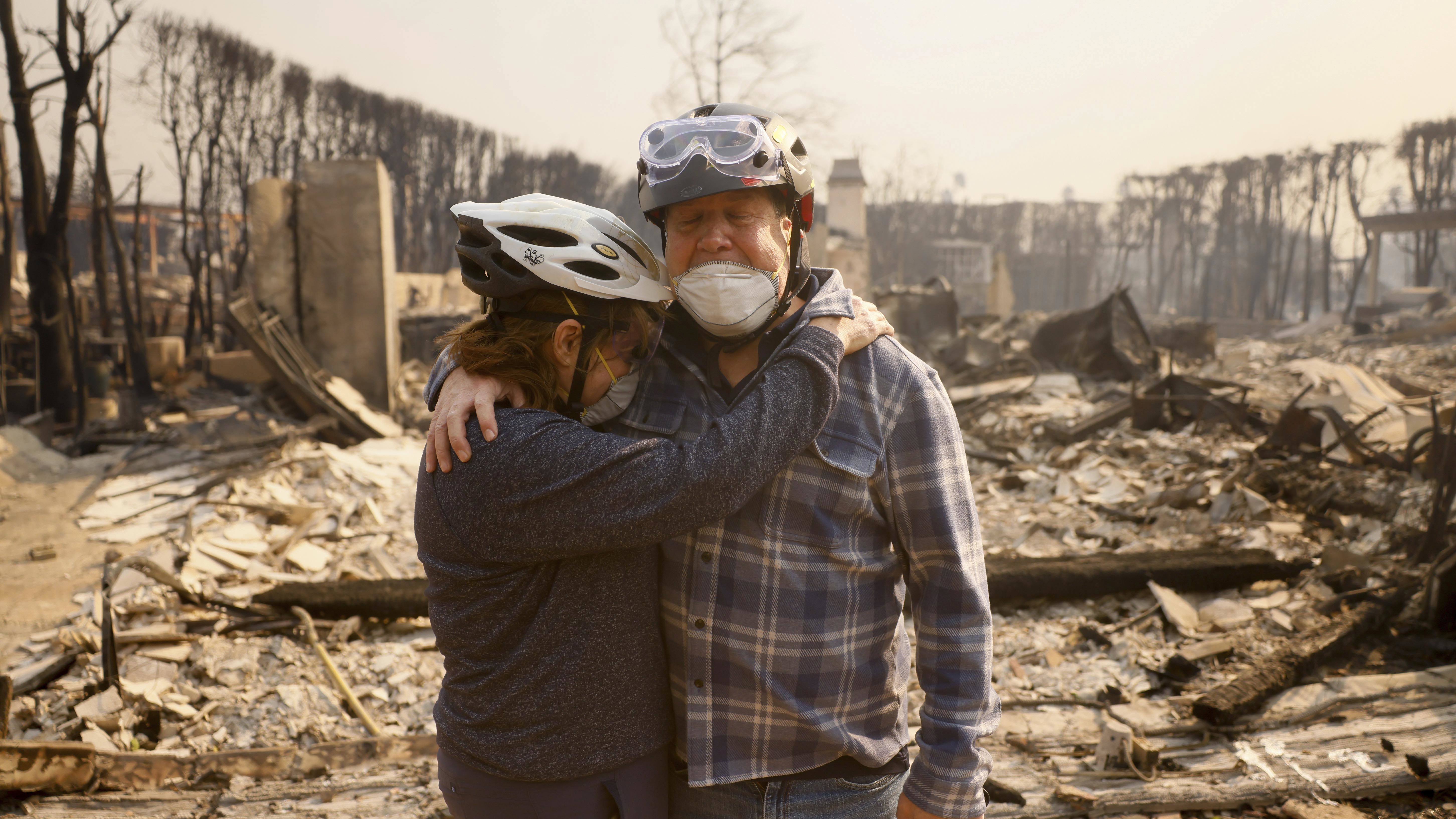 Claudio y Kathleen Boltiansky se abrazan en su vecindario devastado por el incendio después de que el incendio Palisades arrasara el vecindario Pacific Palisades de Los Ángeles, el miércoles 8 de enero de 2025. (Foto AP/Etienne Laurent)