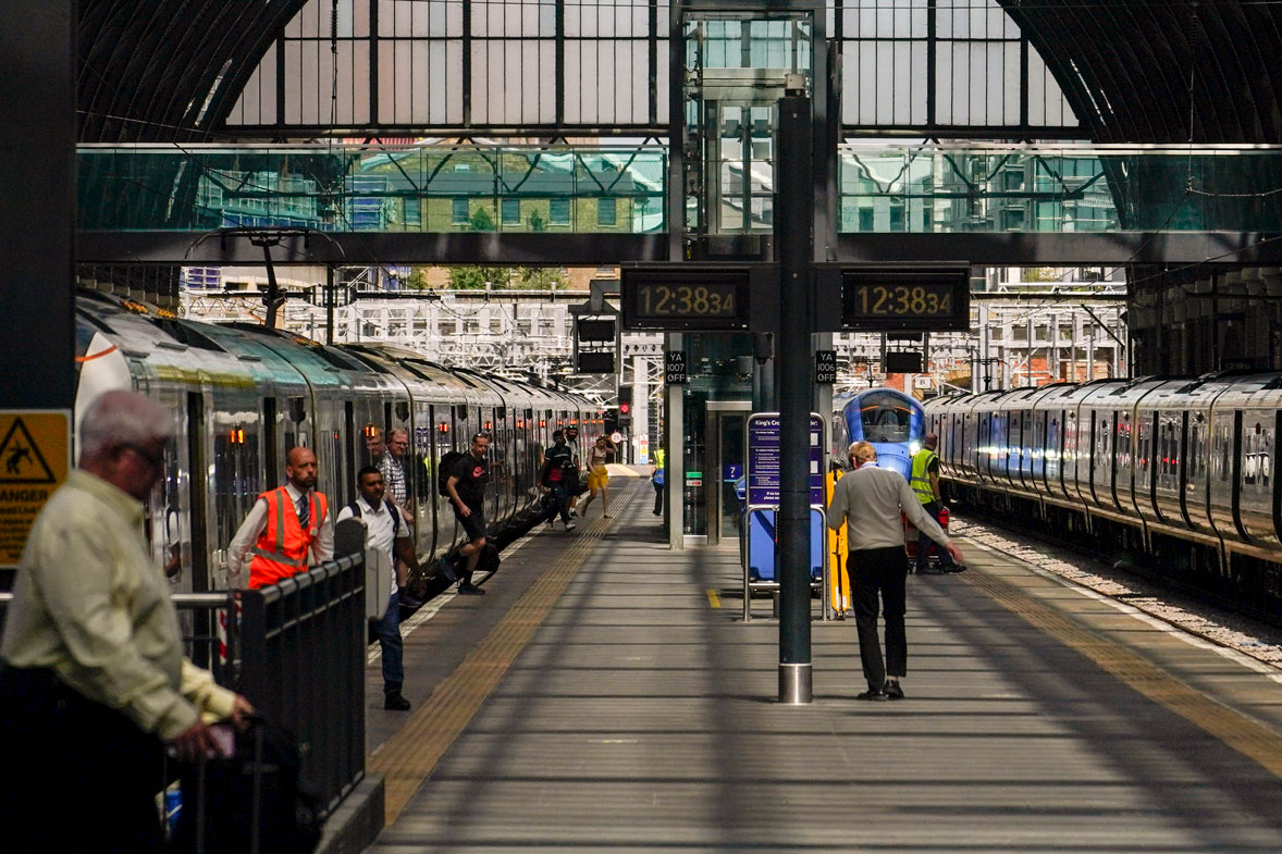 People dismount from a train at King's Cross station, in London, Tuesday, June 21, 2022.