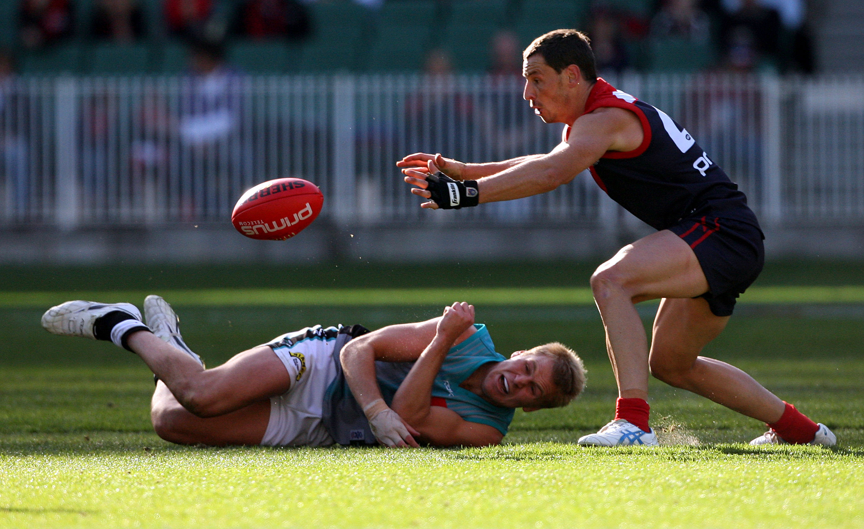 Melbourne s Nathan Brown steels a handball from Port's Kane Cornes.