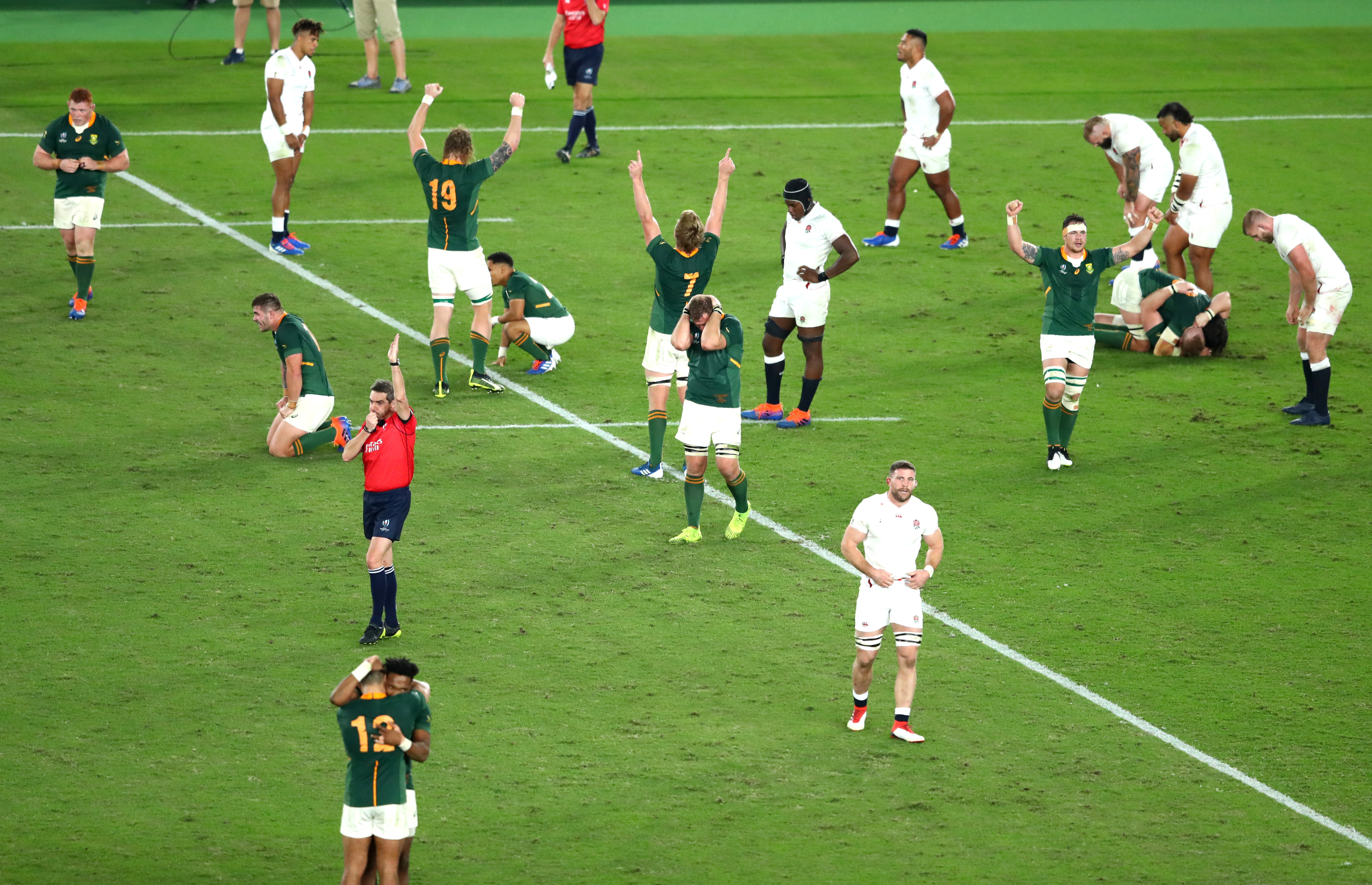 Players of South Africa celebrate victory as the England team react to defeat as referee Jerome Garces blows his whistle during the Rugby World Cup 2019 final.