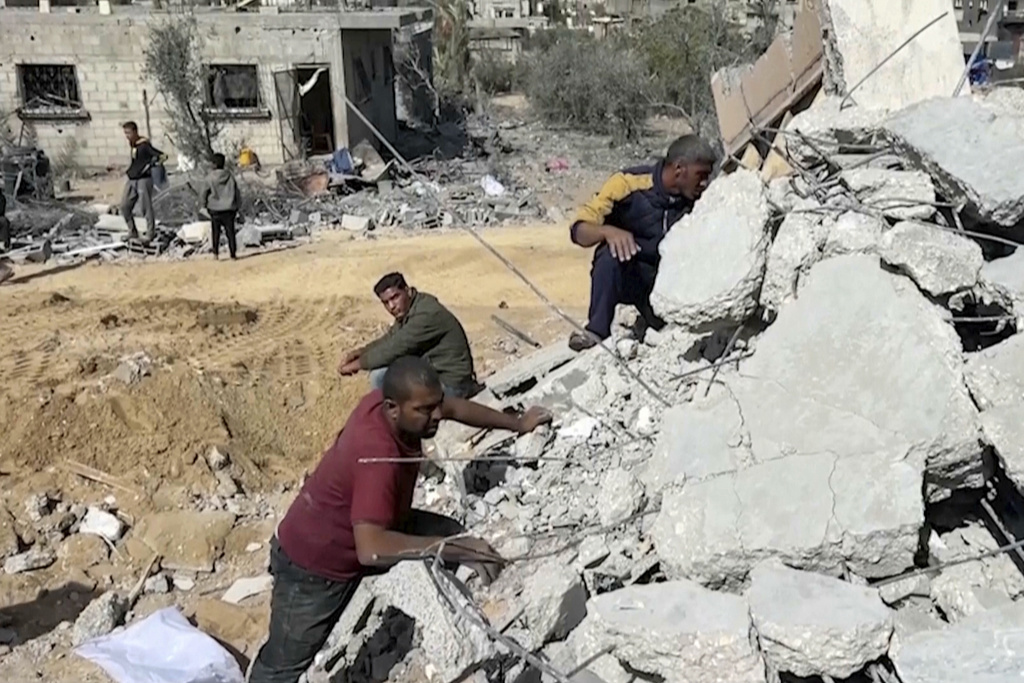 Palestinians sift through the rubble of a building destroyed by Israeli airstrikes in the city of Khan Younis, southern Gaza Strip, Friday, Oct. 25, 2024. (AP Photo)