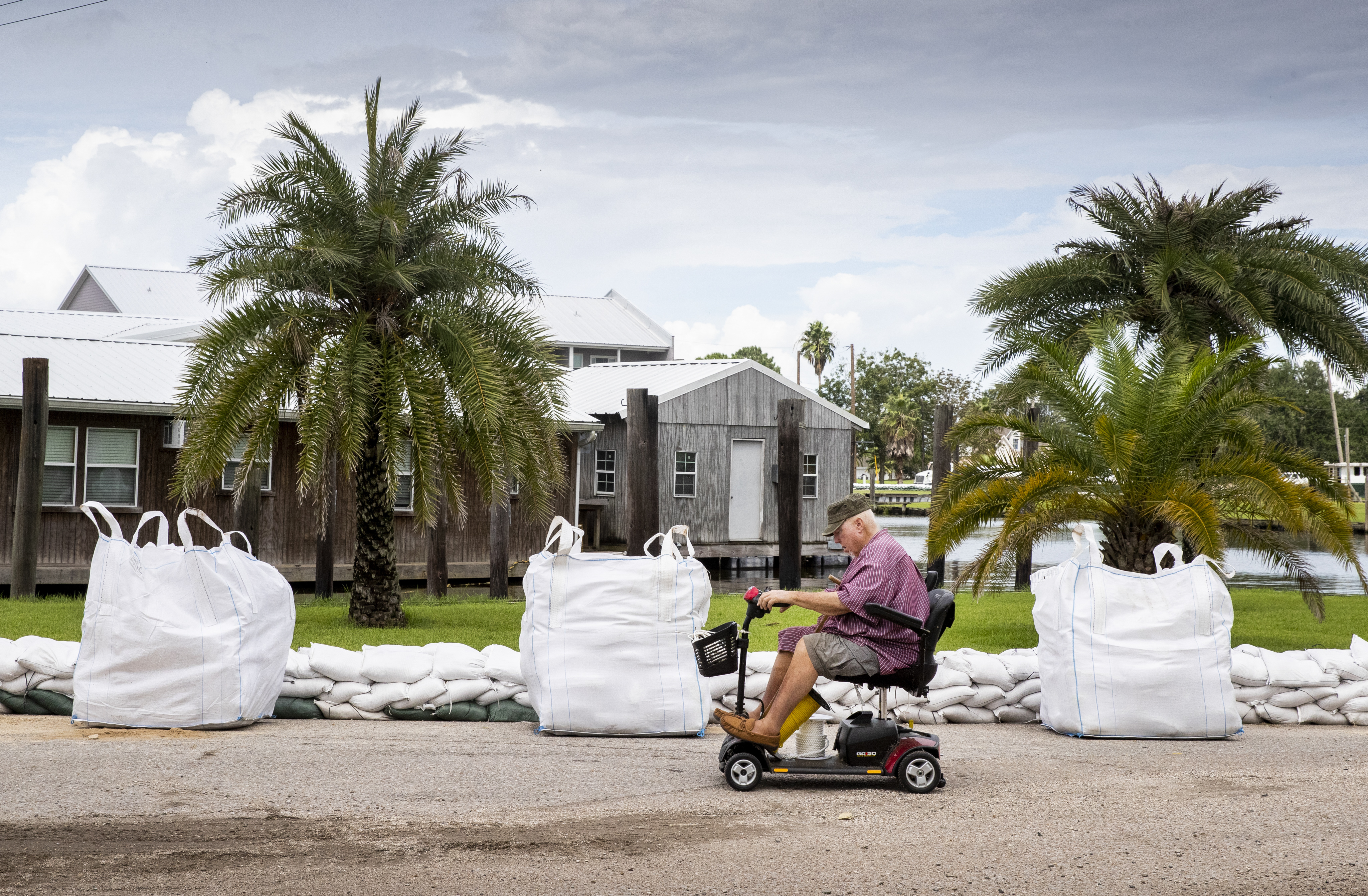 Keith Clark brings a friend rope to help tie down a houseboat before he evacuates to Mandeville ahead of Hurricane Ida in Jean Lafitte, Louisiana. (Photo by Sophia Germer, NOLA.com, The Times-Picayune | The New Orleans Advocate)