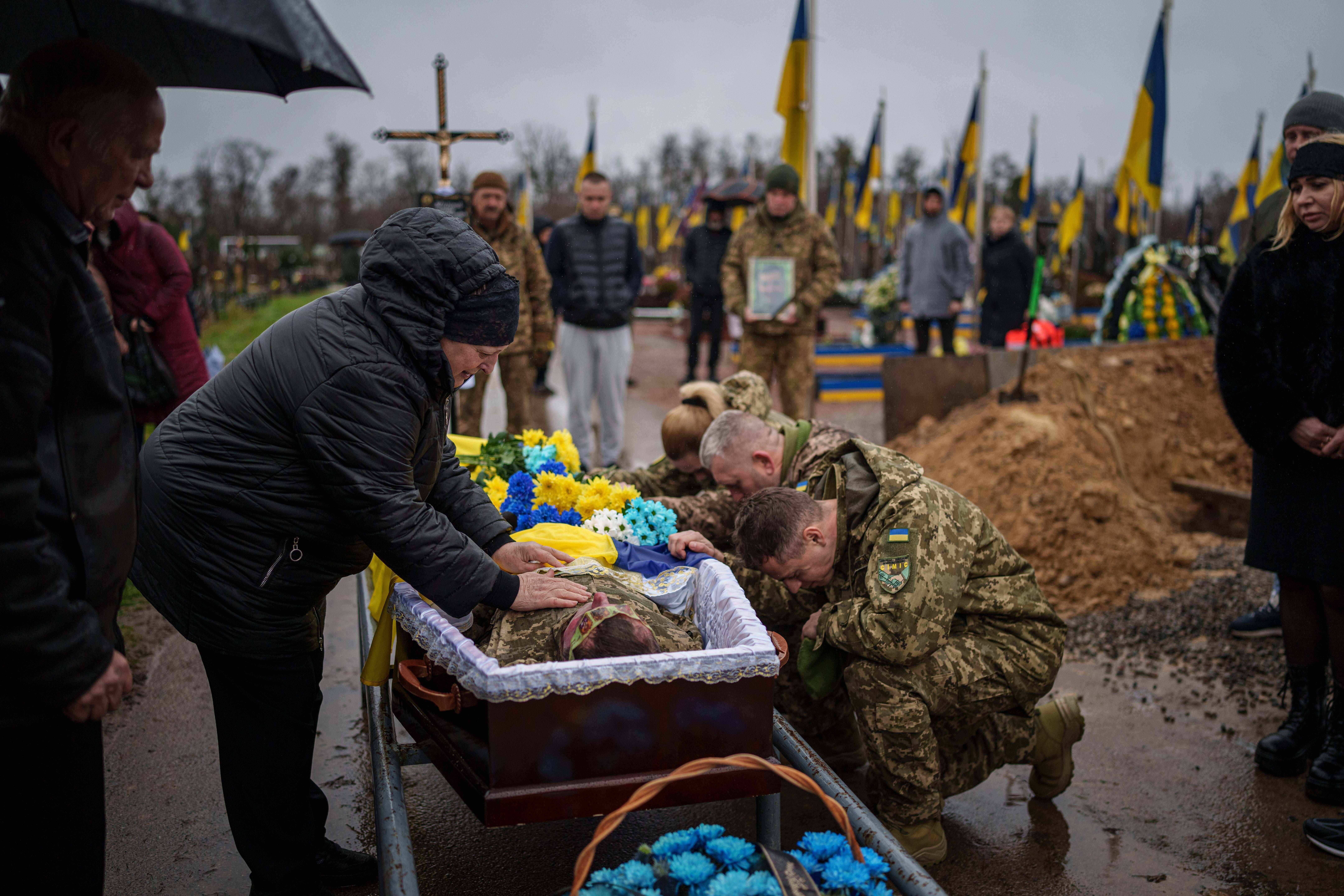 Natalia cries at the coffin of her son Ruslan Zhygunov, a Ukrainian serviceman, who was killed at the frontline near Rusyn Yar village, during his funeral ceremony in Hostomel, Ukraine, on Saturday, Nov. 22, 2025. (AP Photo/Evgeniy Maloletka)