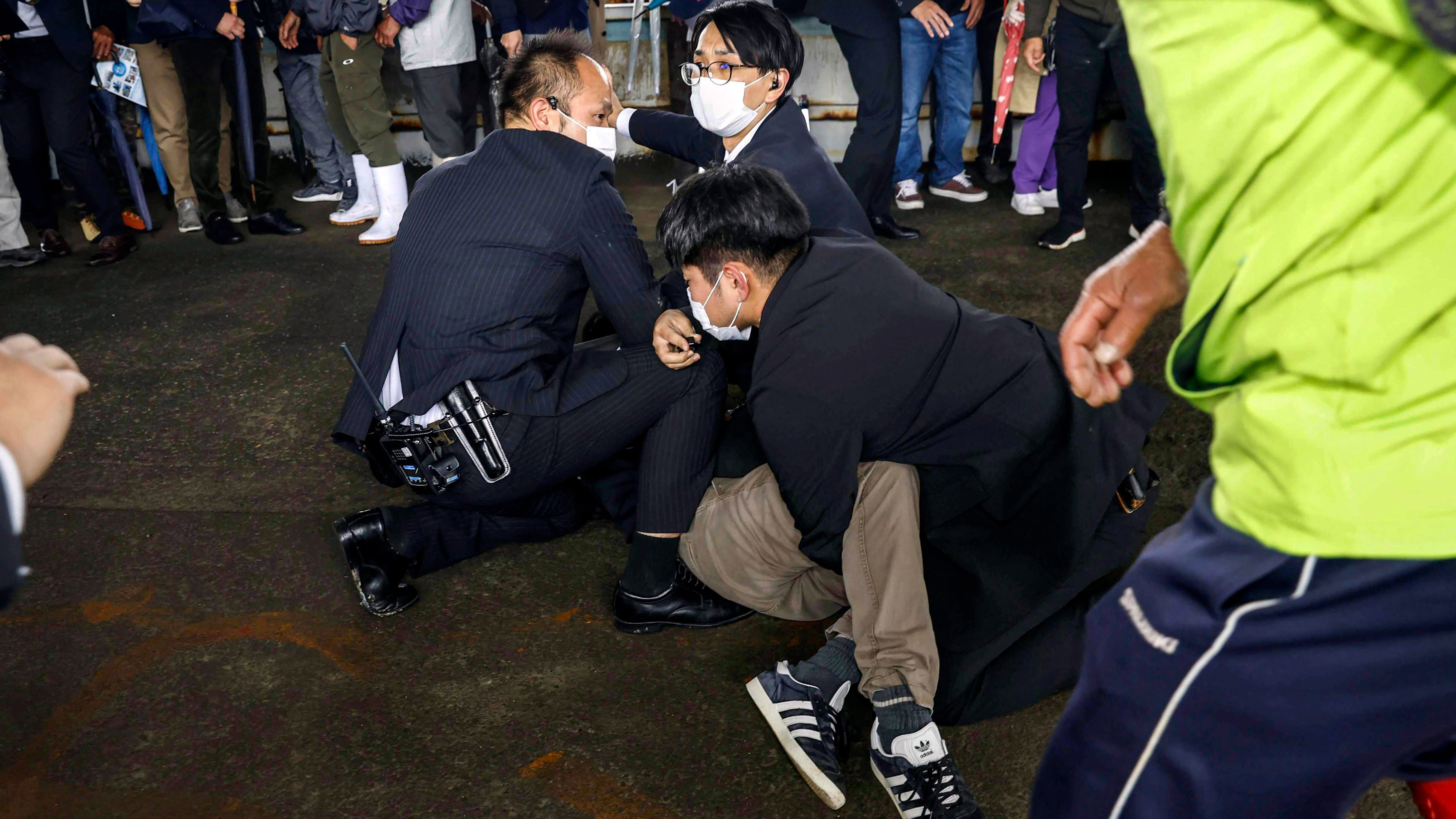 A man, on the ground, who threw what appeared to be a smoke bomb, is arrested by police.