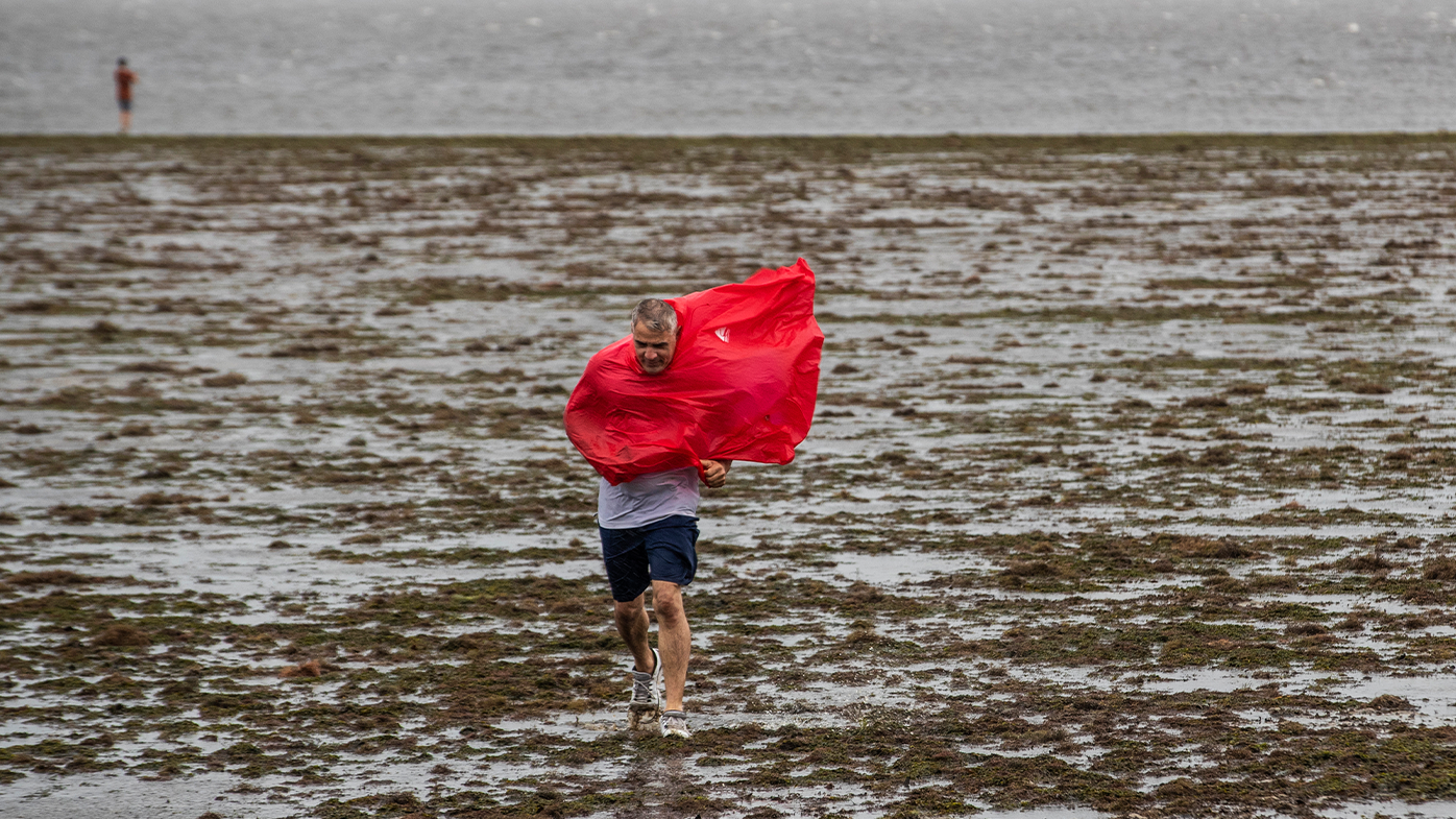 Turistas curiosos caminan en las aguas en retirada de la Bahía de Tampa en Florida debido a la marea baja y los tremendos vientos del huracán Ian.  (Willie J. Allen Jr./Orlando Sentinel vía AP)