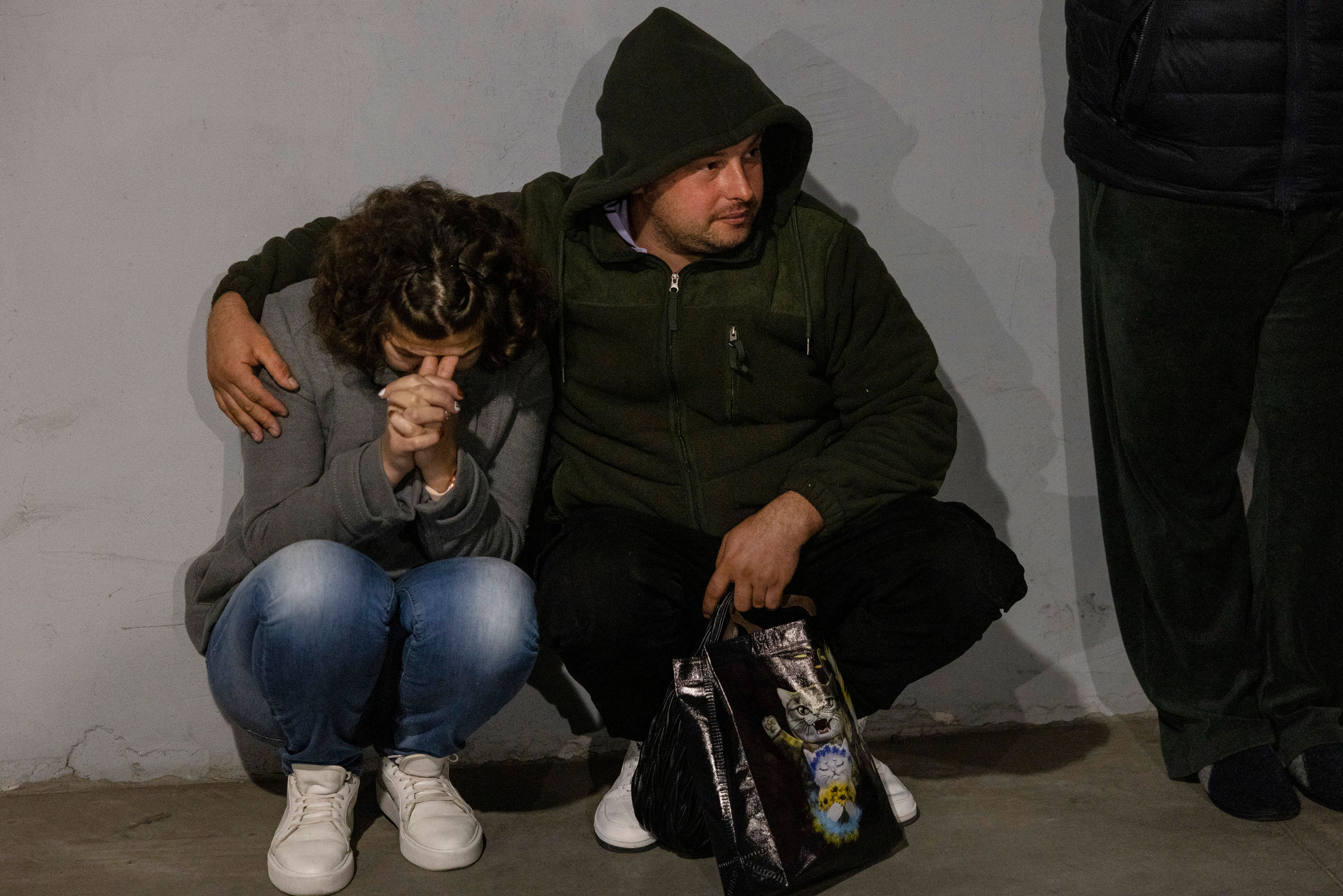 People take cover in a parking lot during an attack from kamikaze drones