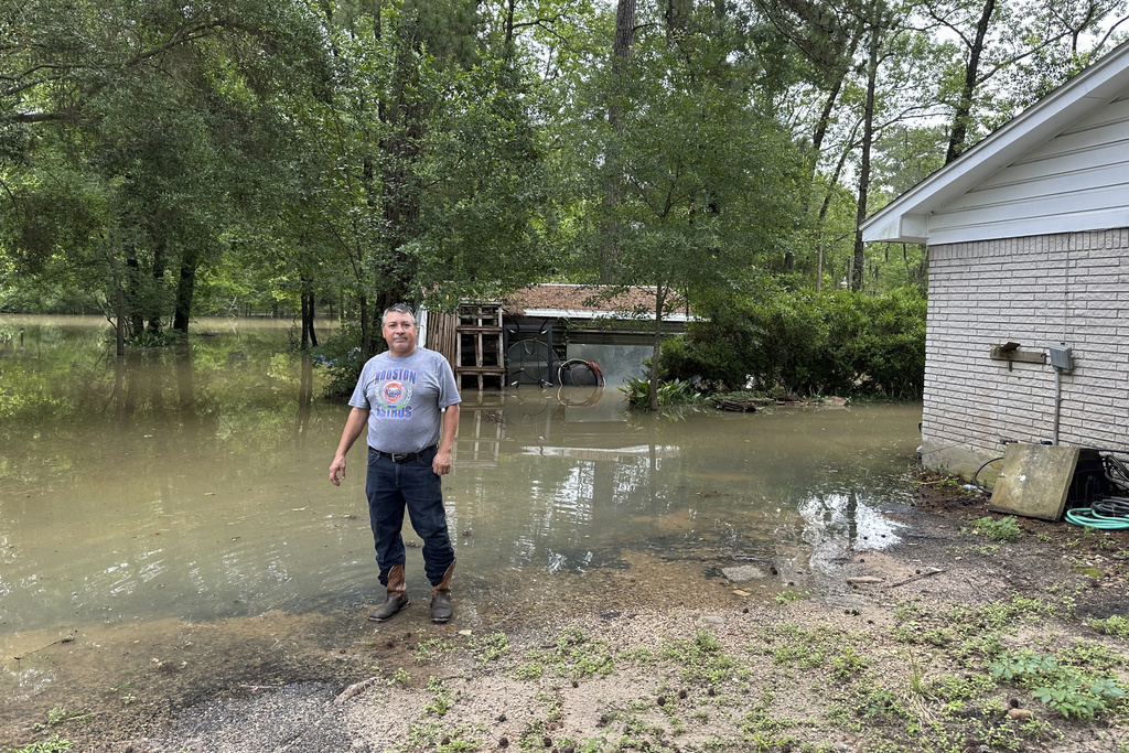 Miguel Flores Sr. stands in his flooded backyard outside his home in the northeast Houston neighborhood of Kingwood on Saturday, May 4, 2024. Officials said the area had about four months of rain in about a weeks time. (AP Photo/Juan Lozano)