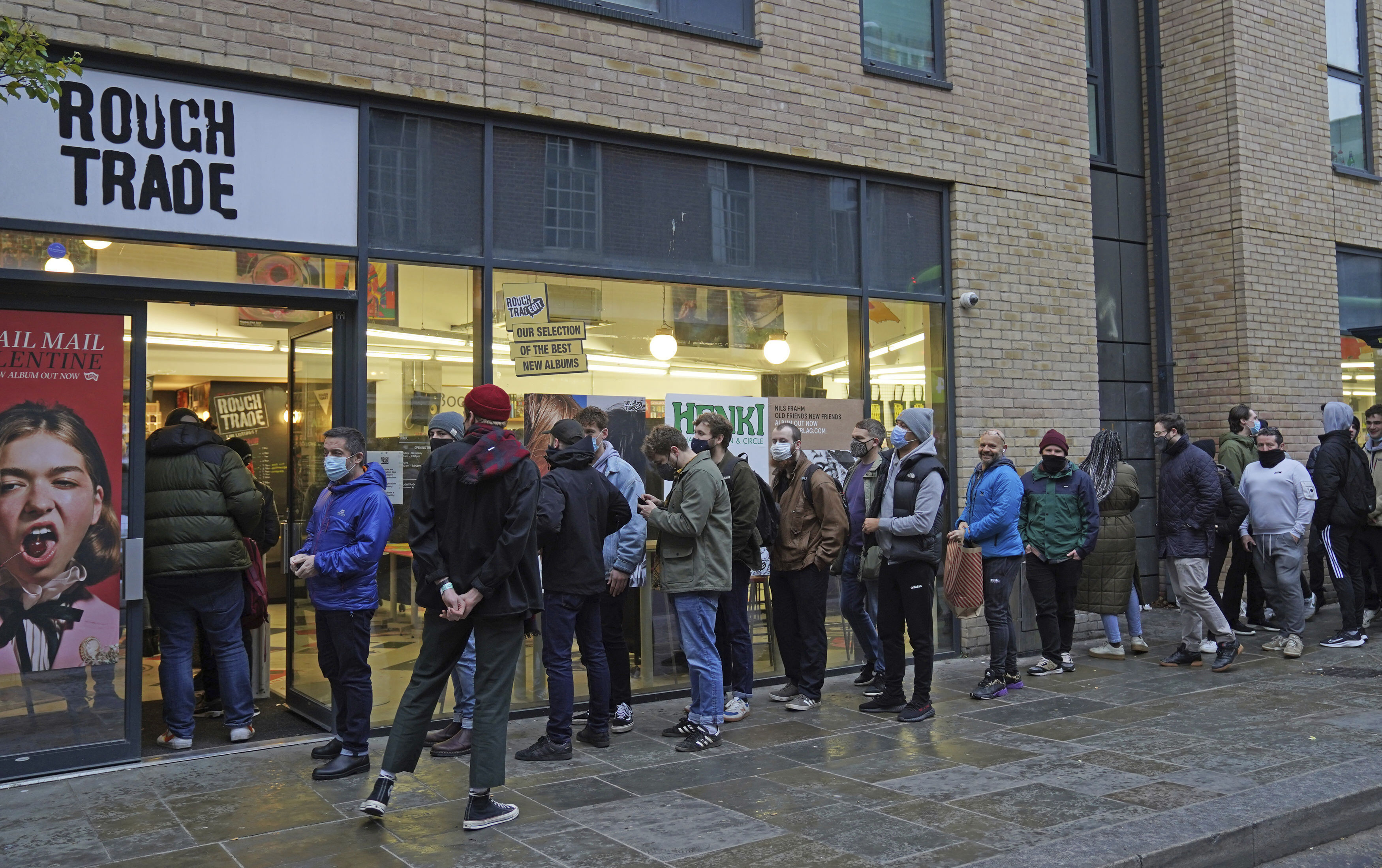 People queue outside Rough Trade in Bristol, England Saturday Dec. 11, 2021 where a T-shirt designed by street artist Banksy is being sold to support four people facing trial accused of criminal damage in relation to the toppling of a statue of slave trader Edward Colston. 