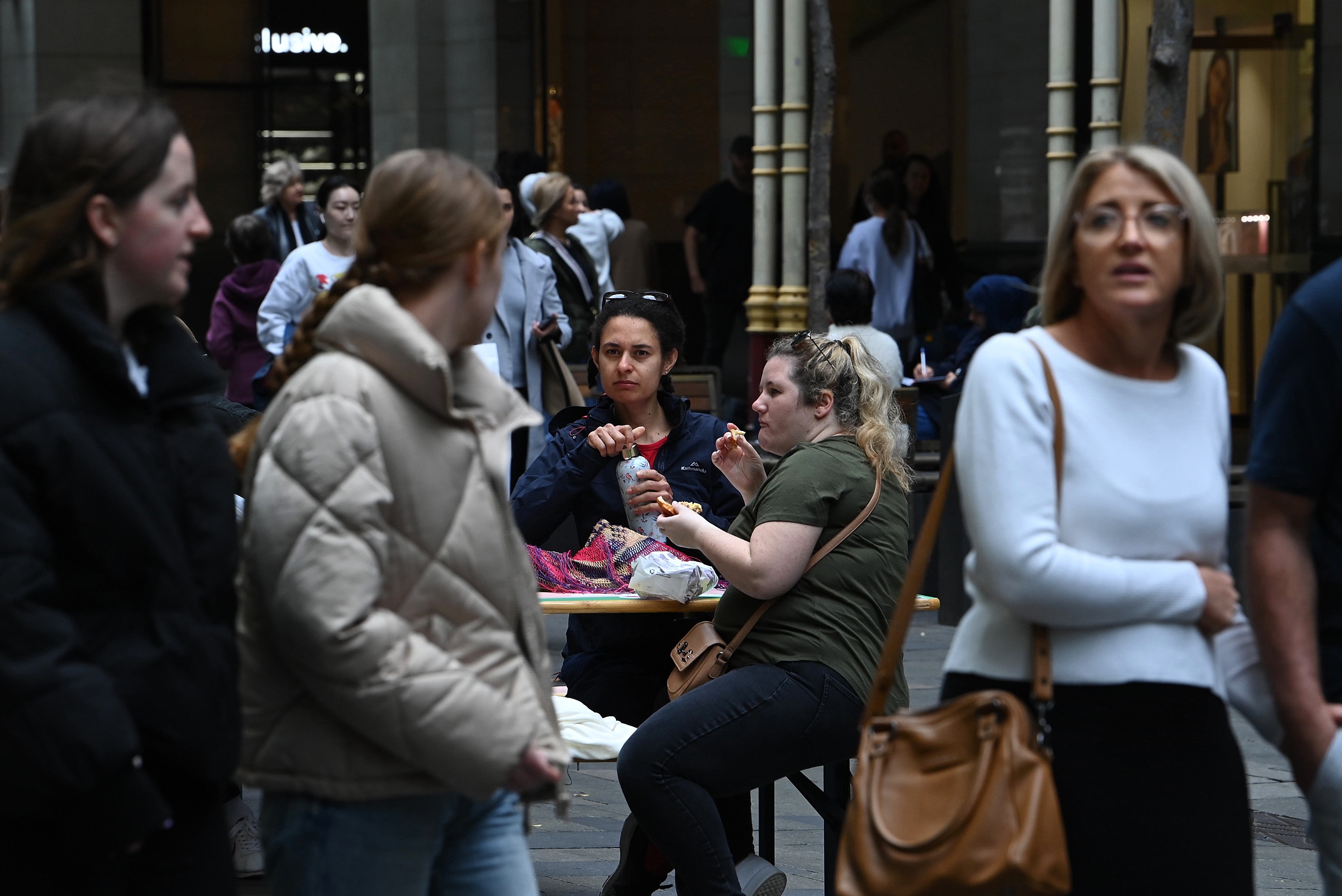 People eat takeaway food in Pitt Street Mall in the CBD of Sydney