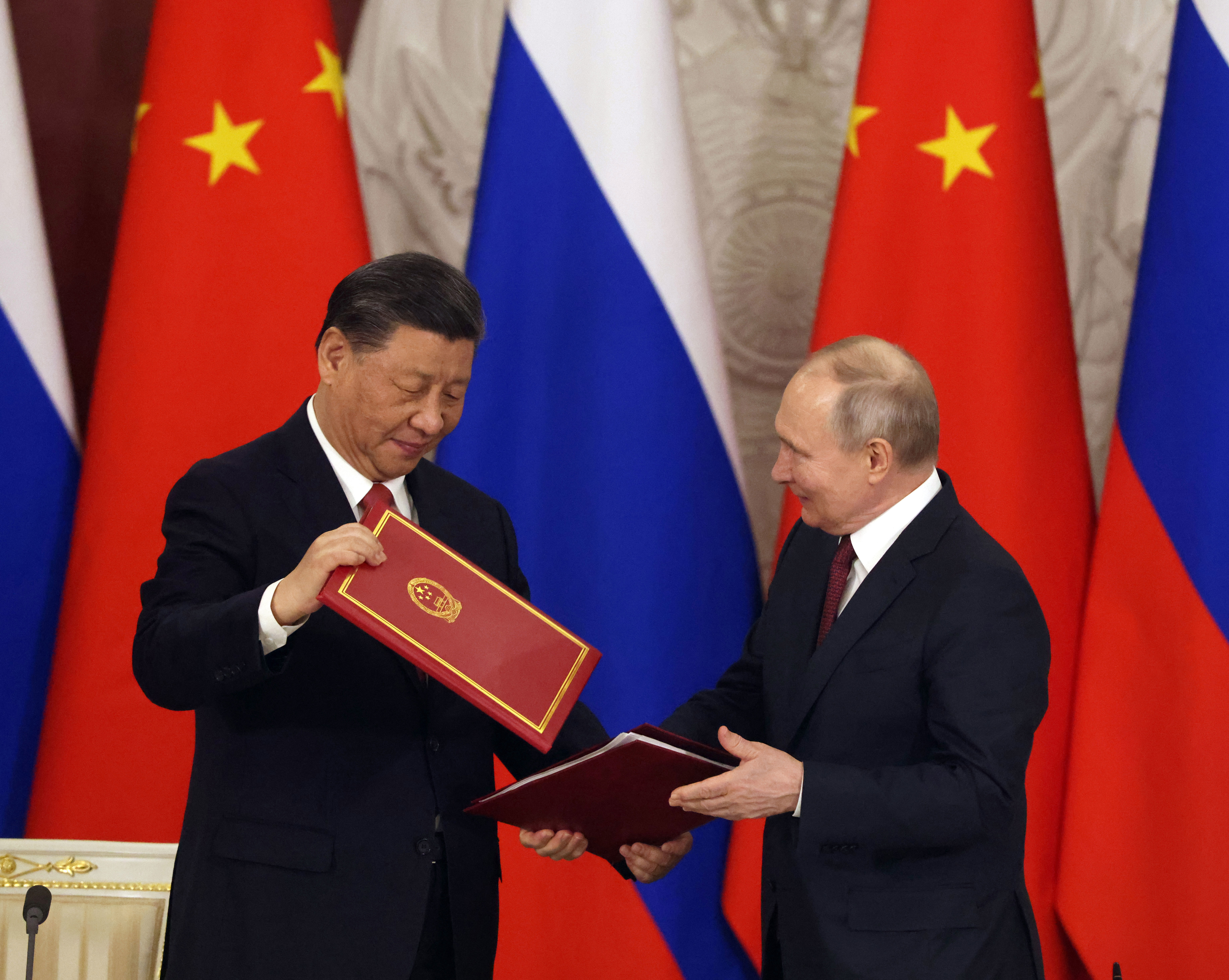 Chinese President Xi Jinping and Russian President Vladimir Putin shake hands.