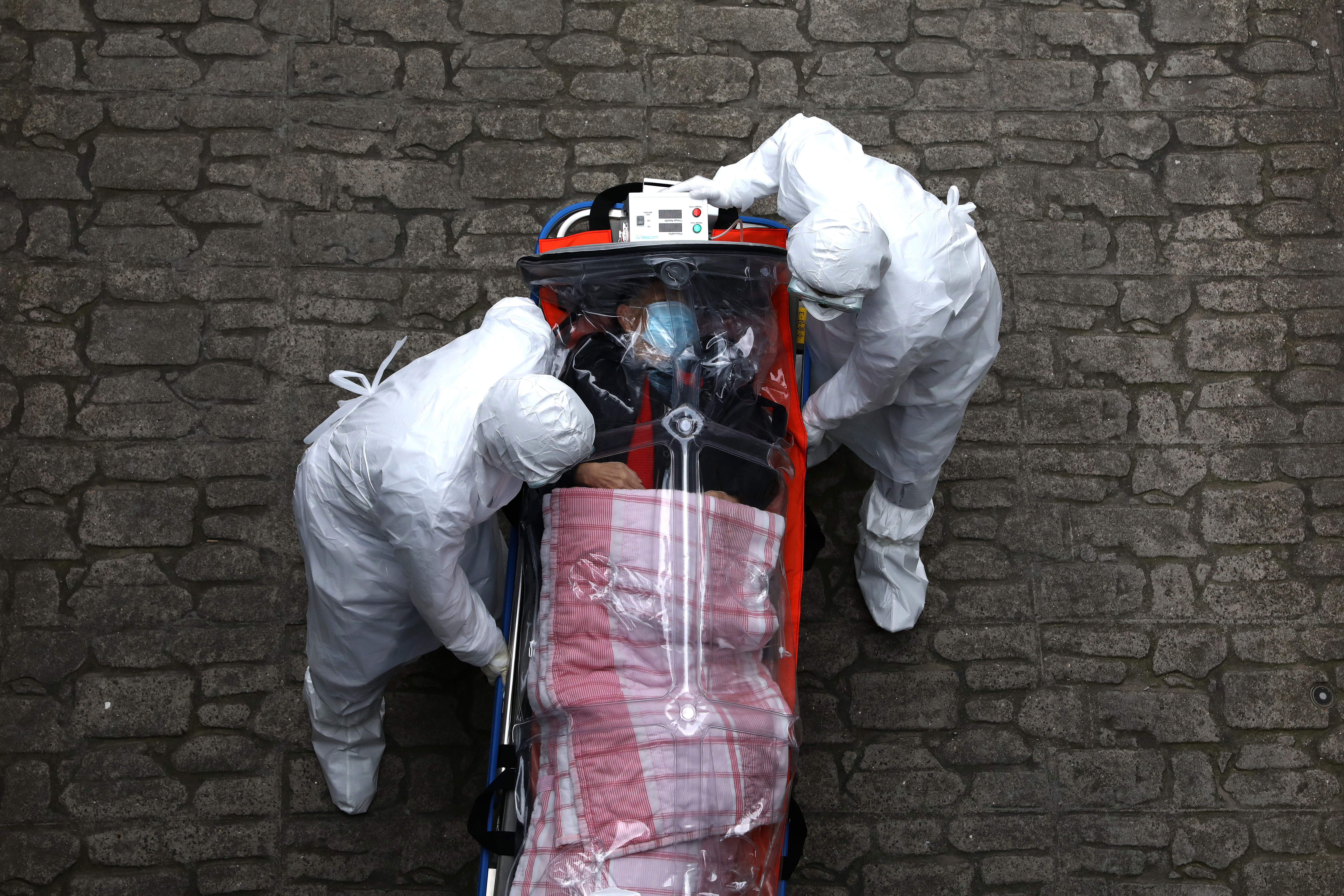 Medical staff, wearing protective gear, move a patient infected with the coronavirus from an ambulance to a hospital in Seoul, South Korea.
