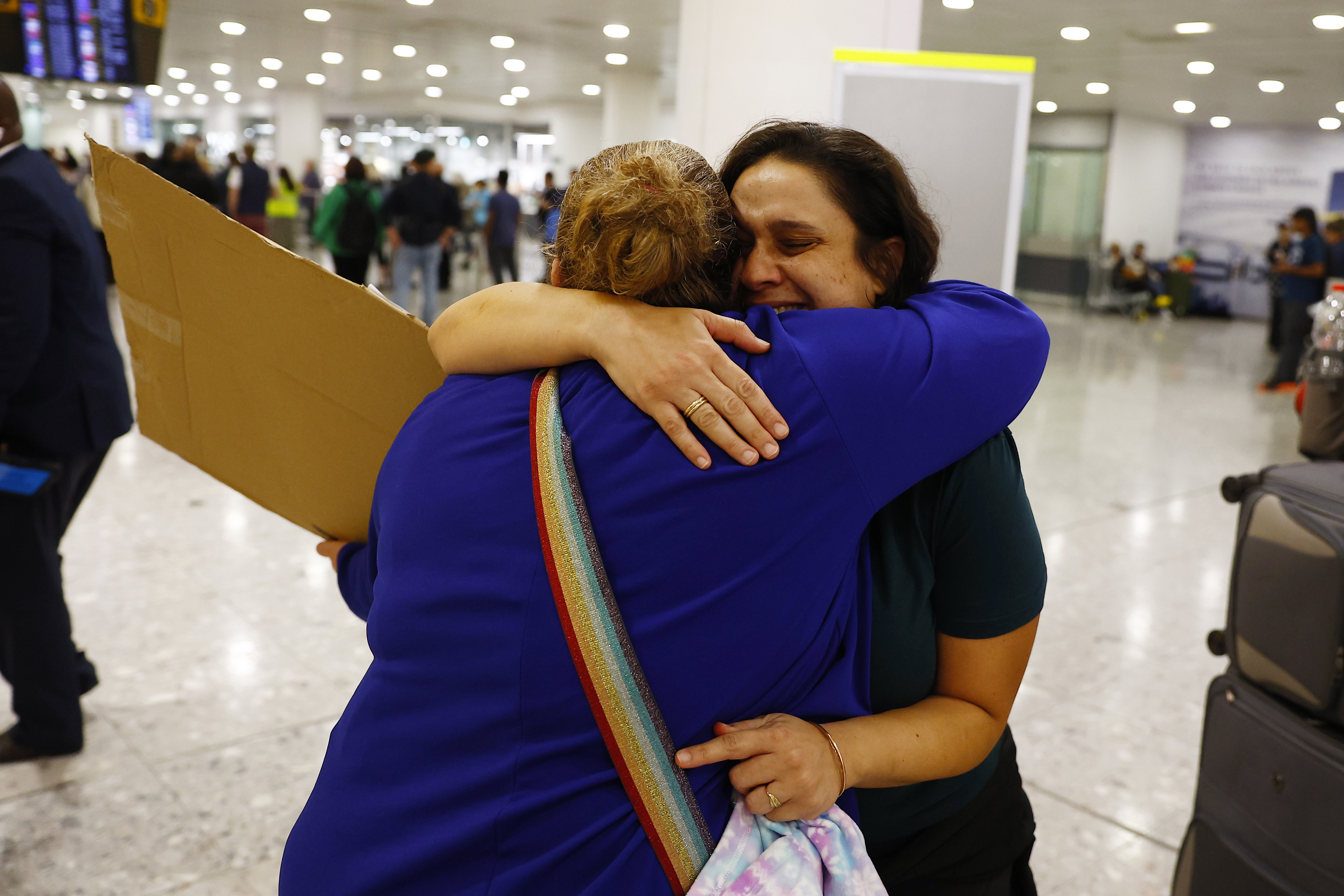 LONDON, ENGLAND - OCTOBER 13: A member of London's Israeli community (L) hugs an Australian citizen evacuated from Israel, at Terminal 3, Heathrow on October 13, 2023 in London, England. 238 Australian nationals are on the flight to London Heathrow following the Hamas surprise attack on Israel last Saturday left 1300 dead and as many as 150 people were taken hostage and moved to Gaza. (Photo by Peter Nicholls/Getty Images)