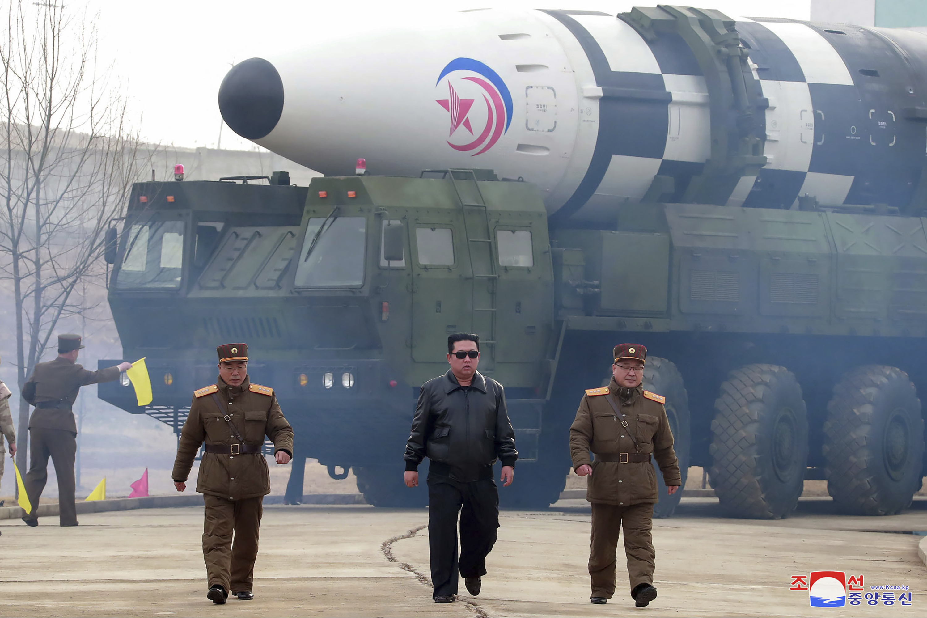 North Korean leader Kim Jong Un, center, walks around the alleged Hwasong-17 intercontinental ballistic missile. 
