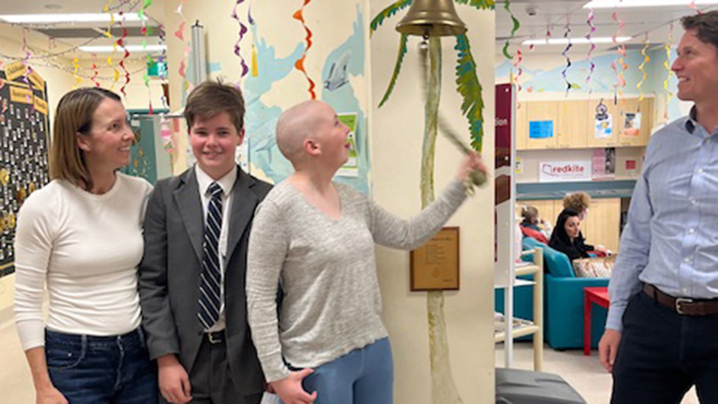 Millie rings the bell to celebrate being cancer-free.