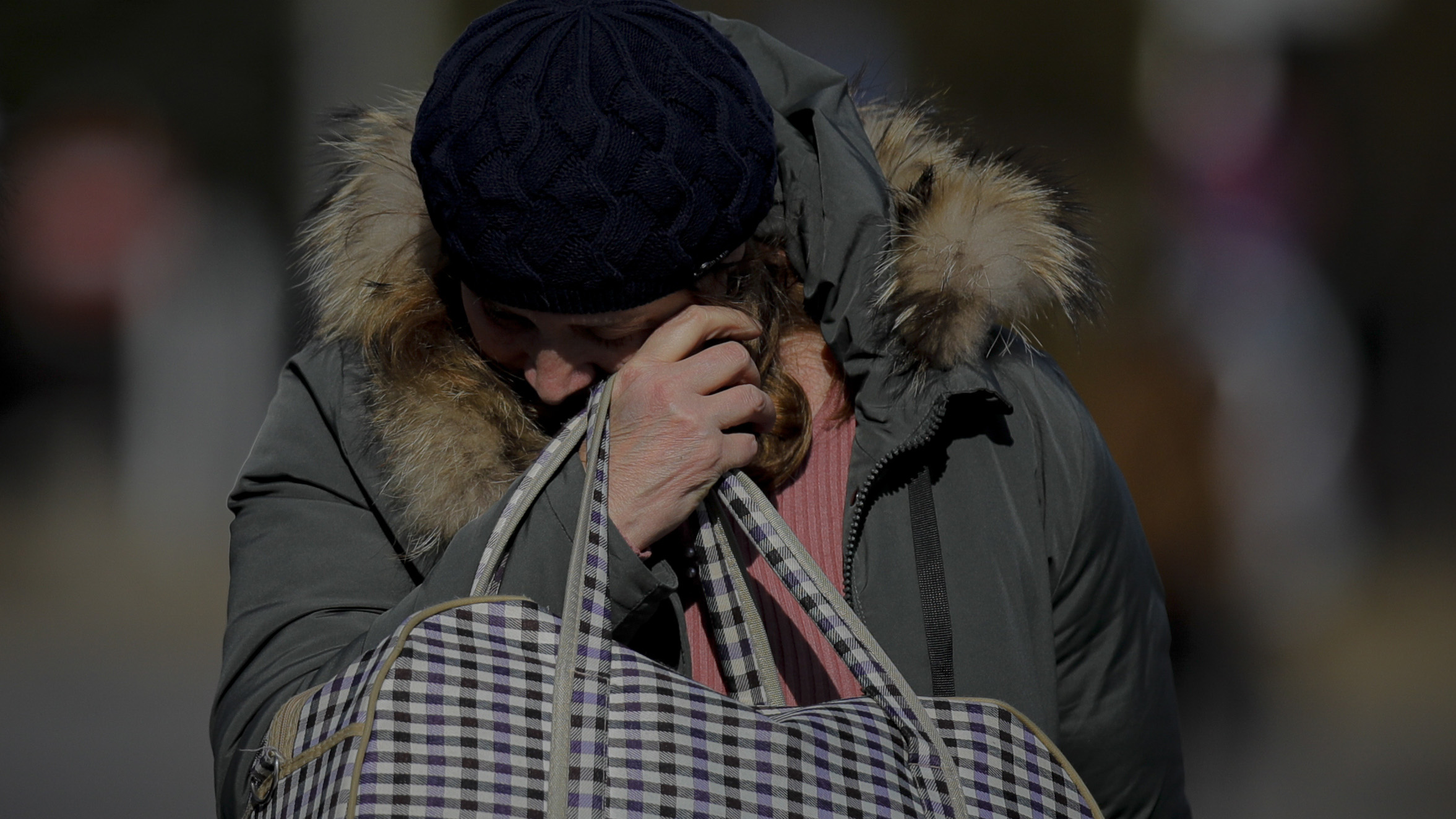 A woman wipes away tears after she crossed the border from Ukraine at the Romanian-Ukrainian border, in Siret, Romania.