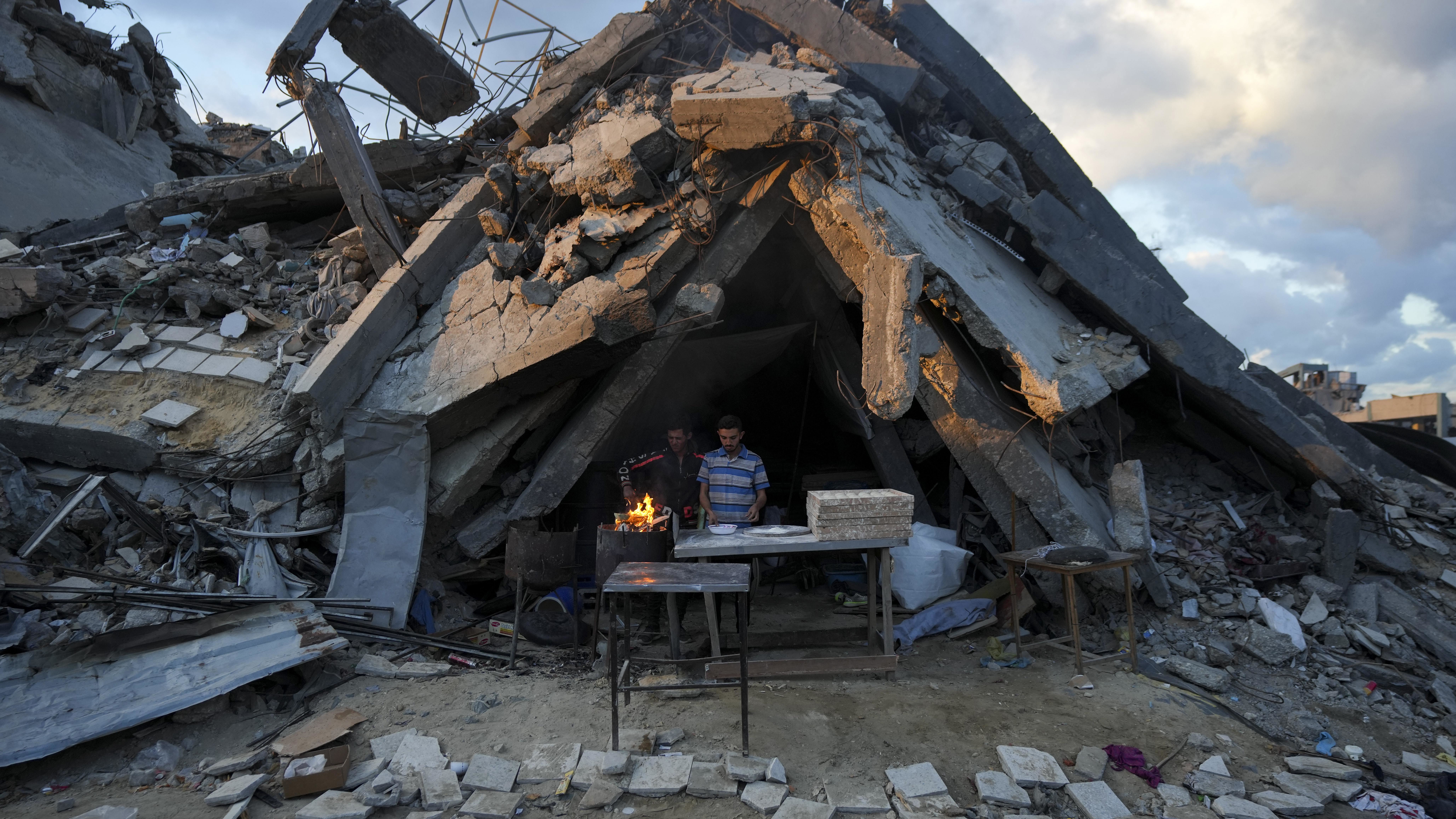 A man sells bread under the destruction of his bakery destroyed by the Israeli air and ground offensive in Jabaliya, Gaza Strip.