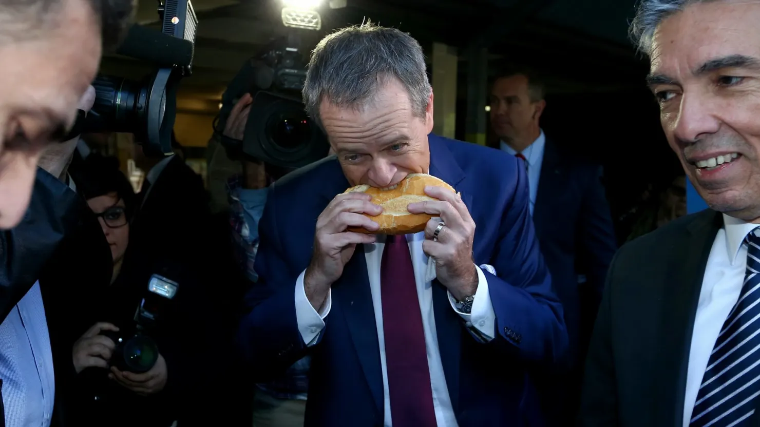 Bill Shorten tackles a sausage sizzle in an unconventional manner in 2016.